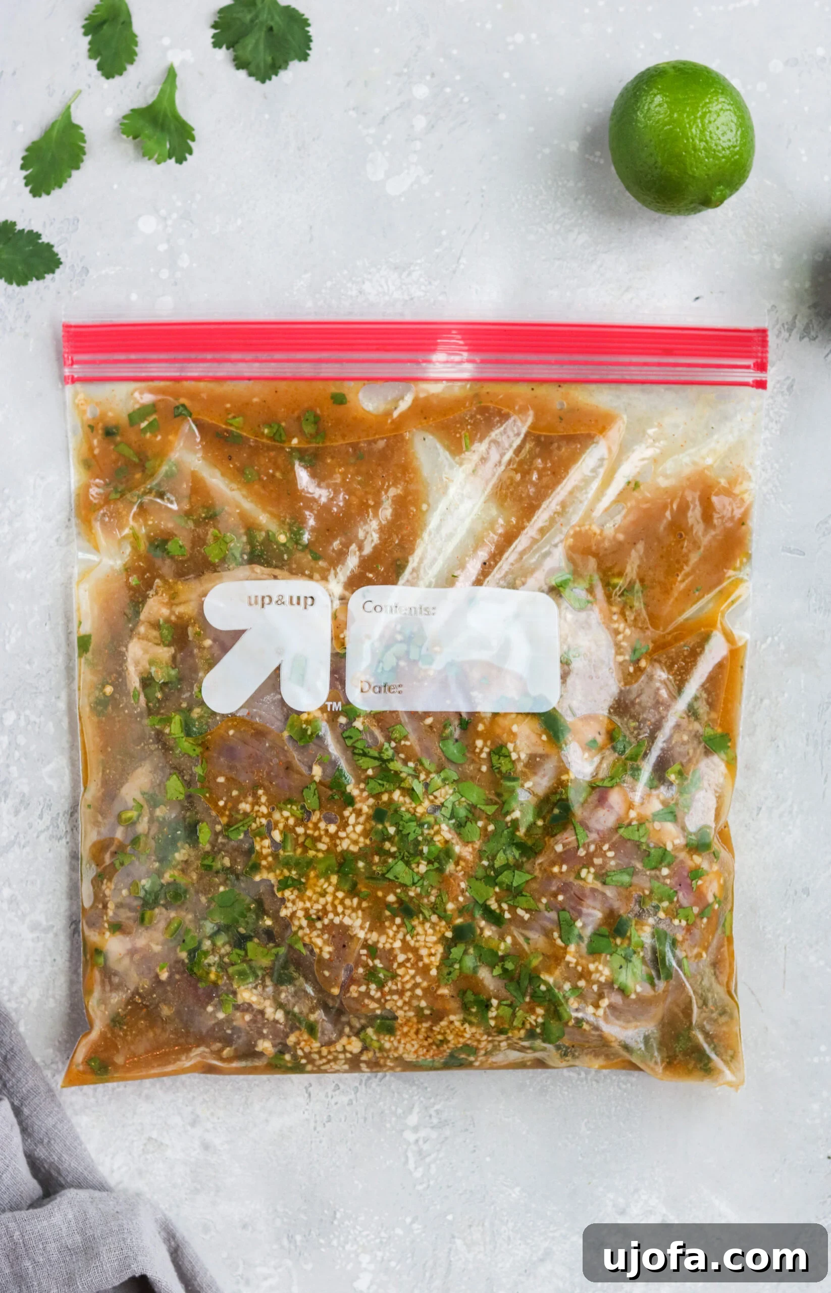 Raw flank steak generously coated in a vibrant carne asada marinade