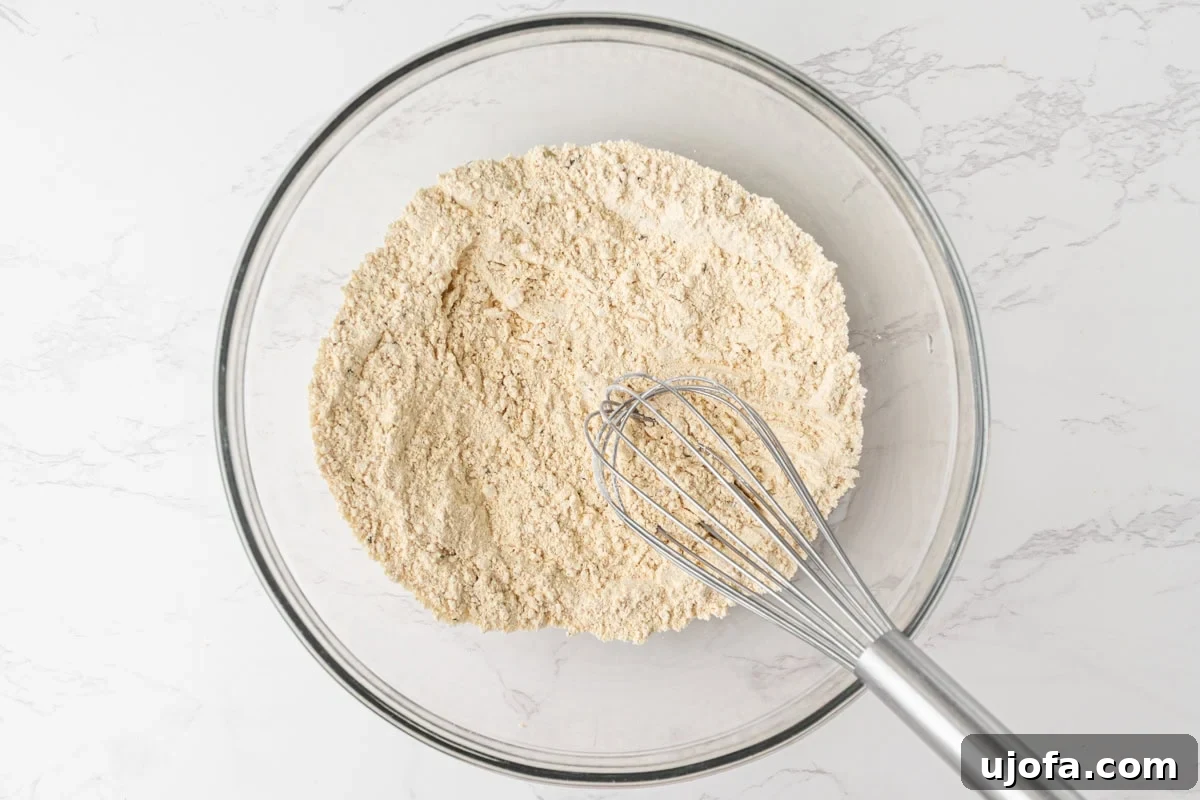 Chickpea flour in a glass mixing bowl with a whisk