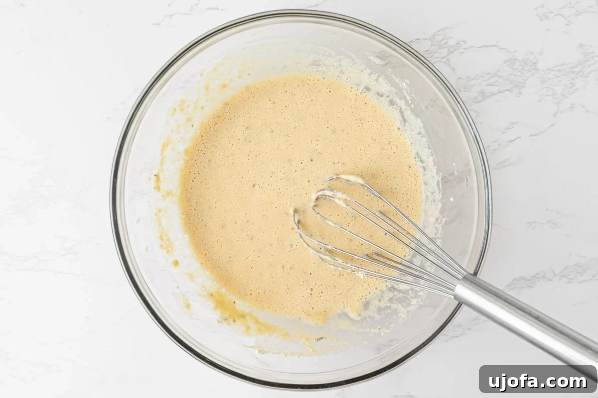 Chickpea pizza crust batter whisked smooth in a glass bowl