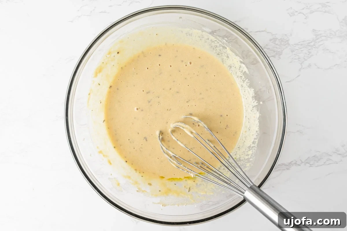 Chickpea pizza crust batter rested and ready to use in a glass bowl