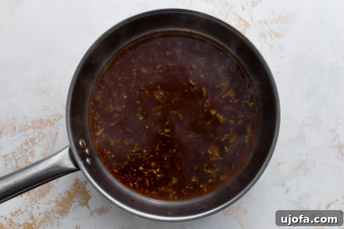 Gluten-free General Tso’s sauce simmering in a skillet before thickening