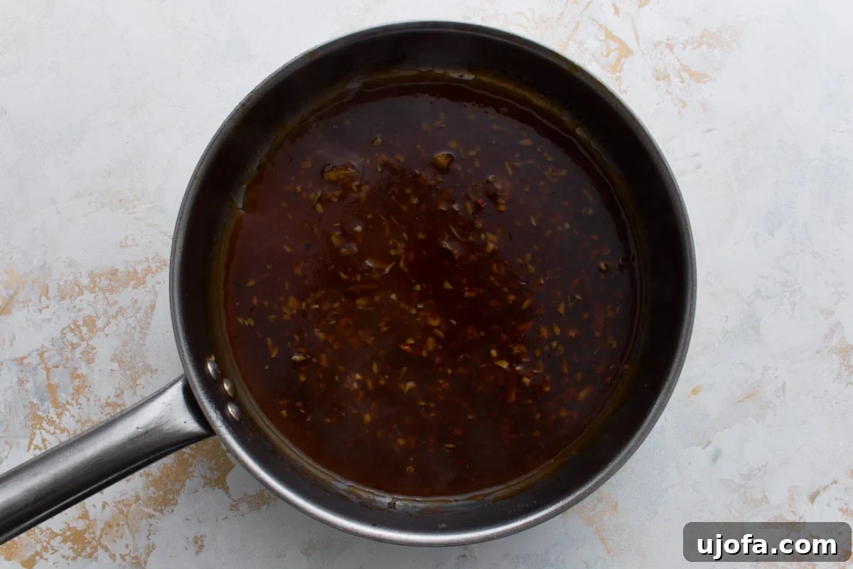 Gluten-free General Tso’s sauce simmering in a skillet until thickened and glossy