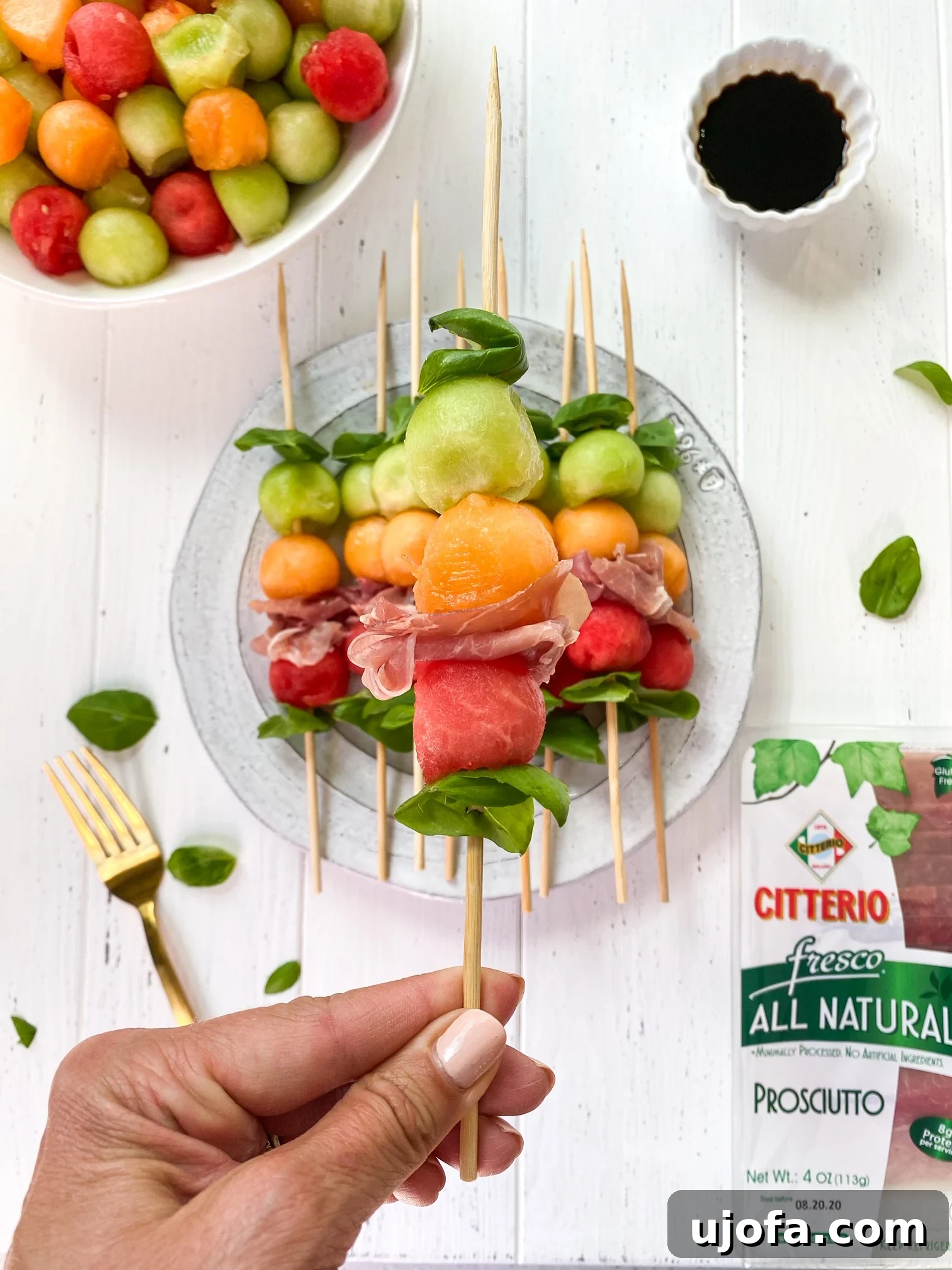 Whole30 Sweet and Savory Melon Prosciutto Skewers 6 Close-up of a single Whole30 Melon Basil Prosciutto Skewer on a wooden board.