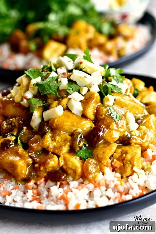 Creamy Golden Turmeric Coconut Chicken Curry Paleo AIP 2 Gluten-Free Turmeric Coconut Chicken Curry on a plate with cauliflower rice with another serving in the background