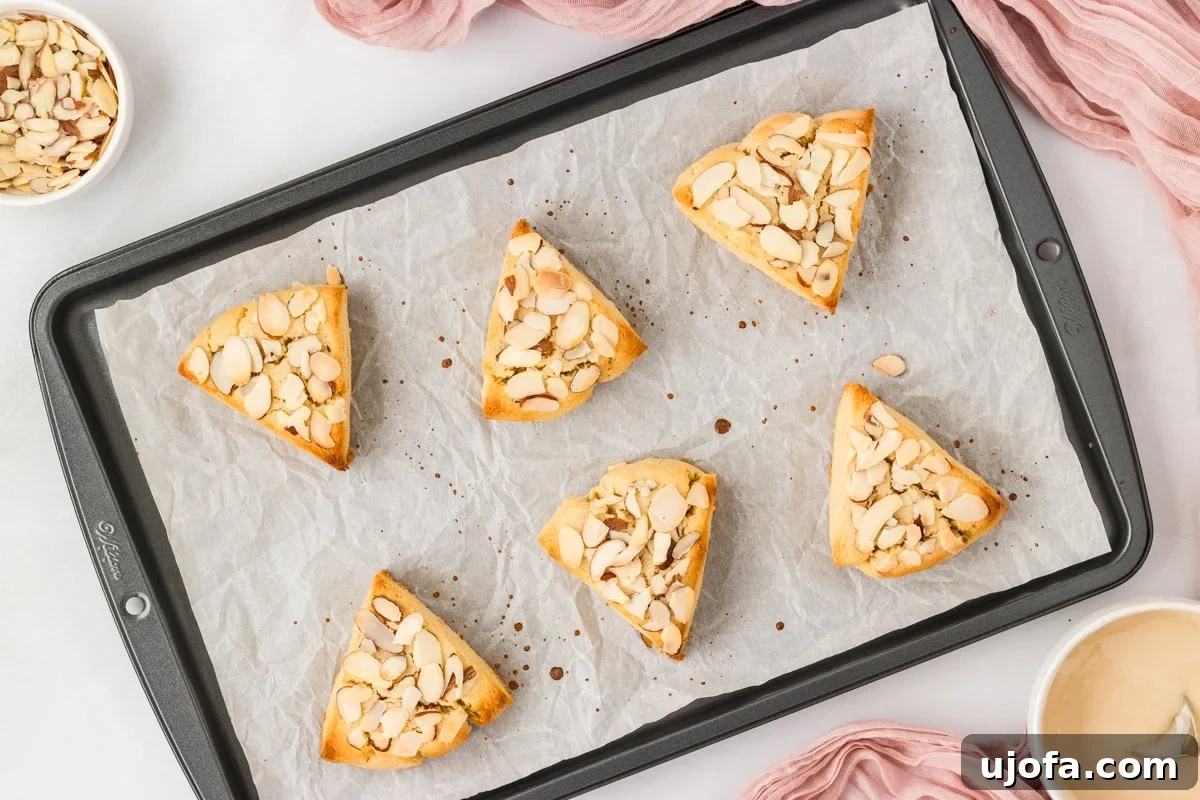 Tender Almond Scones 13 Baked almond flour scones with sliced almonds on parchment lined baking sheet