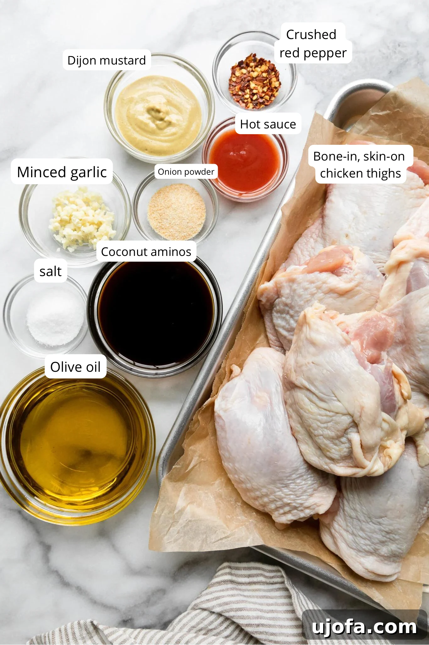 Juicy Keto Chicken Thighs with a Healthy Zesty Marinade 3 A collection of fresh ingredients laid out, including chicken thighs, olive oil, coconut aminos, and various spices, ready for making the marinade.