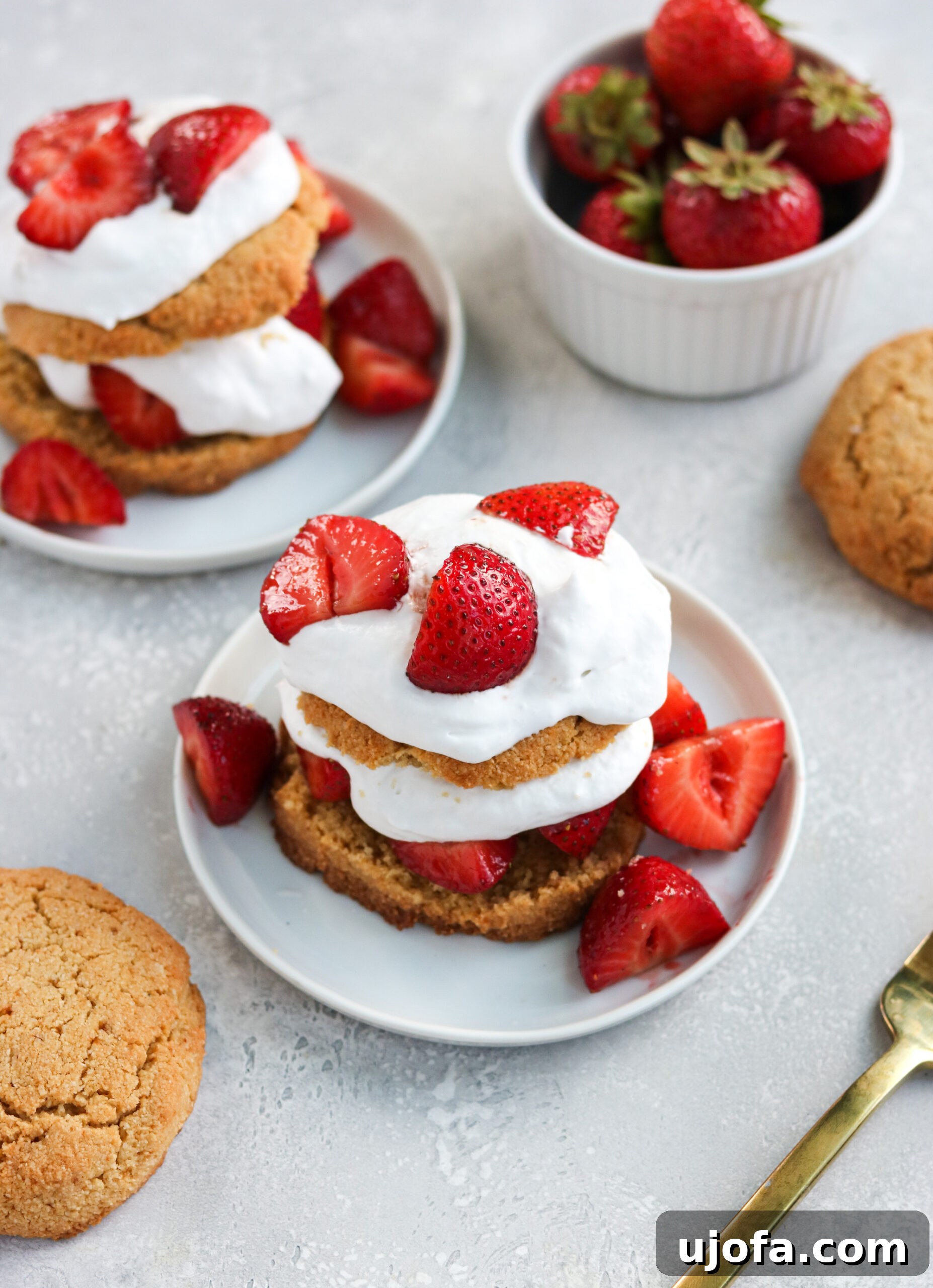 Irresistible Paleo Strawberry Shortcake 3 Two halves of a Paleo Strawberry Shortcake biscuit filled with fresh strawberries and whipped cream.