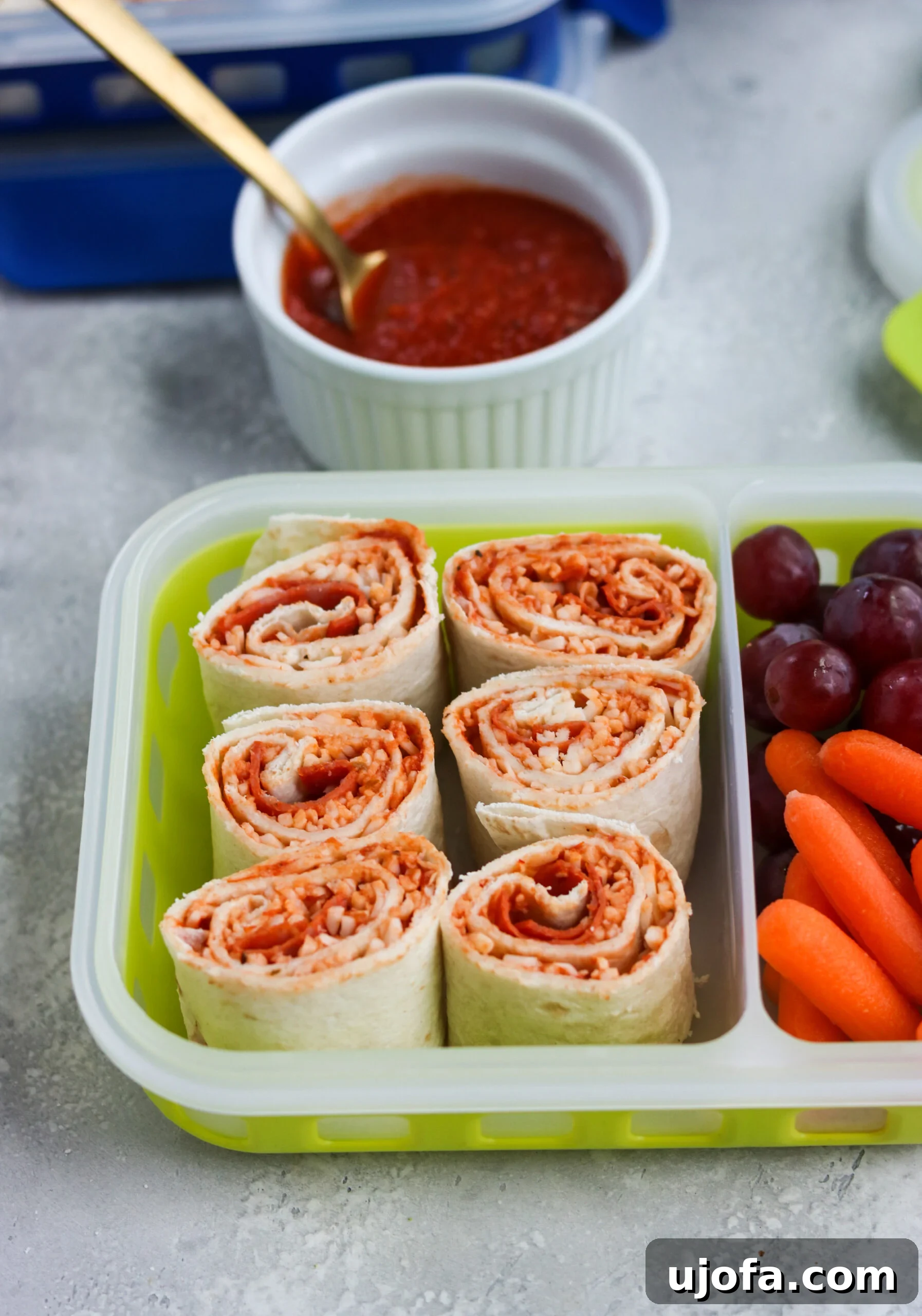 A close-up shot of freshly prepared Pizza Pinwheels with visible pepperoni and melted cheese, cut into bite-sized pieces.