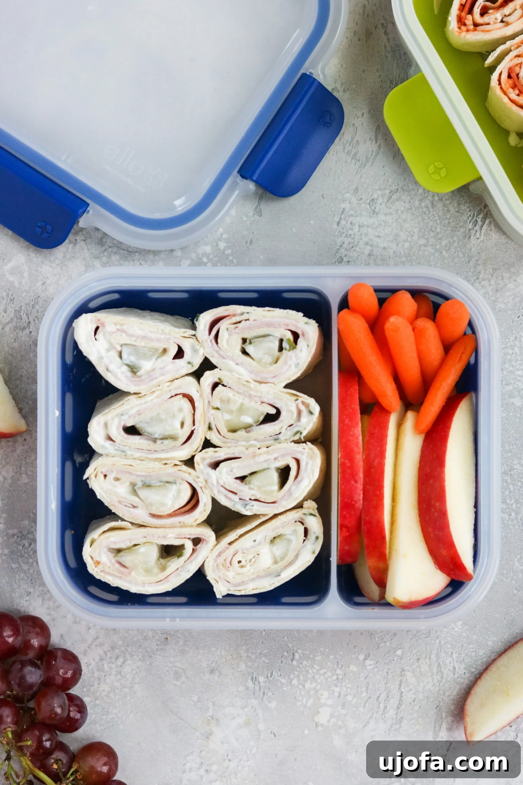 Ham, Pickle, and Cream Cheese Pinwheels beautifully arranged in an Ello Sammie Kids Lunch Container, showcasing their vibrant layers.