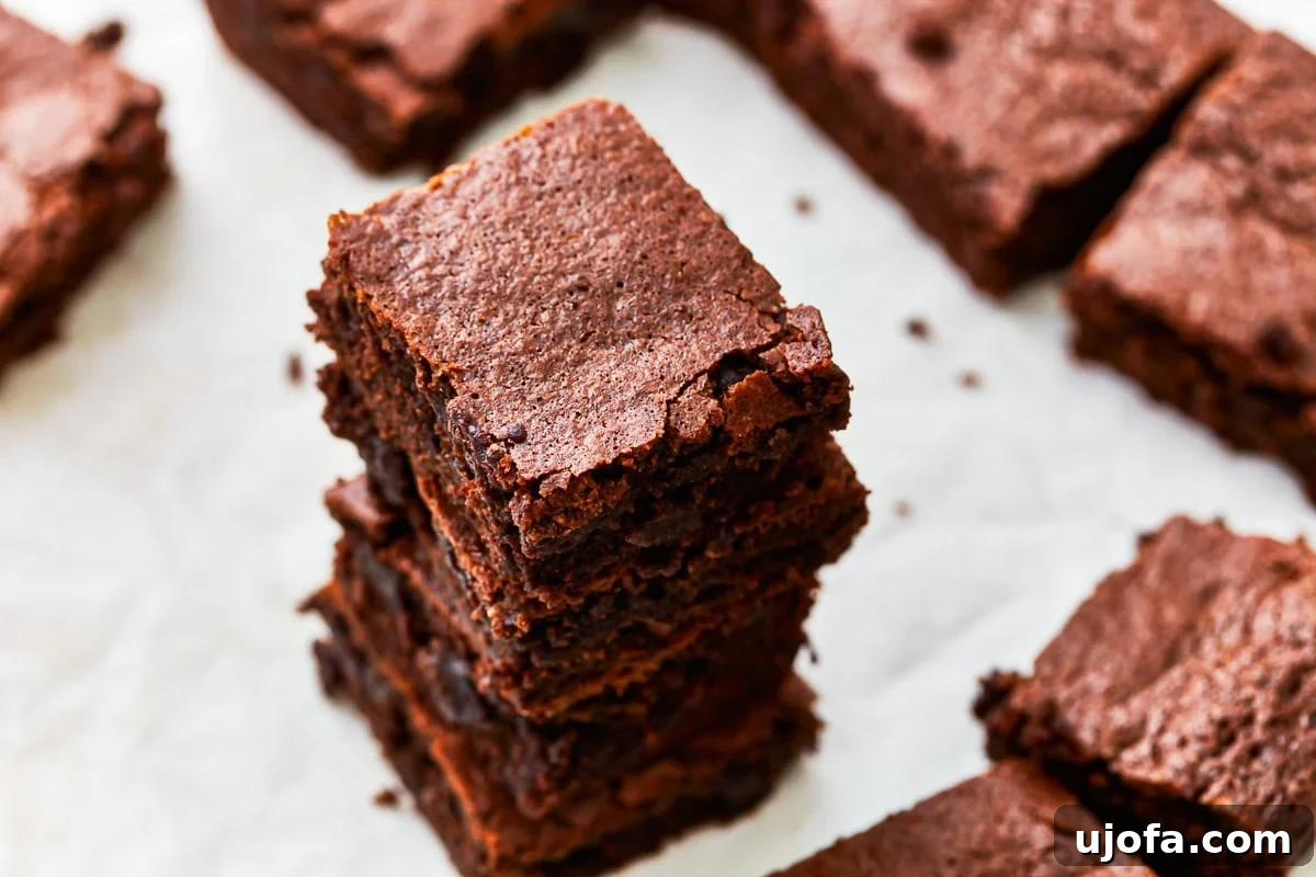 Fudgy Gluten-Free Brownie Perfection 5 An overhead shot of four perfectly stacked gluten-free brownies, showcasing their rich, dark chocolate color and crumbly texture.