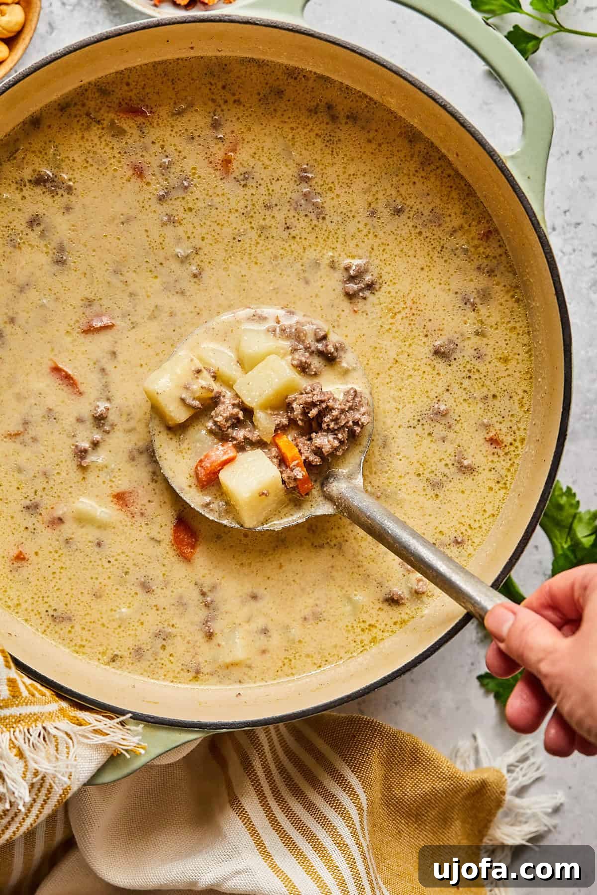 Creamy Dairy-Free Bacon Cheeseburger Soup 10 Creamy dairy-free cheeseburger soup simmering in a pot with a spoon, showing its rich texture.