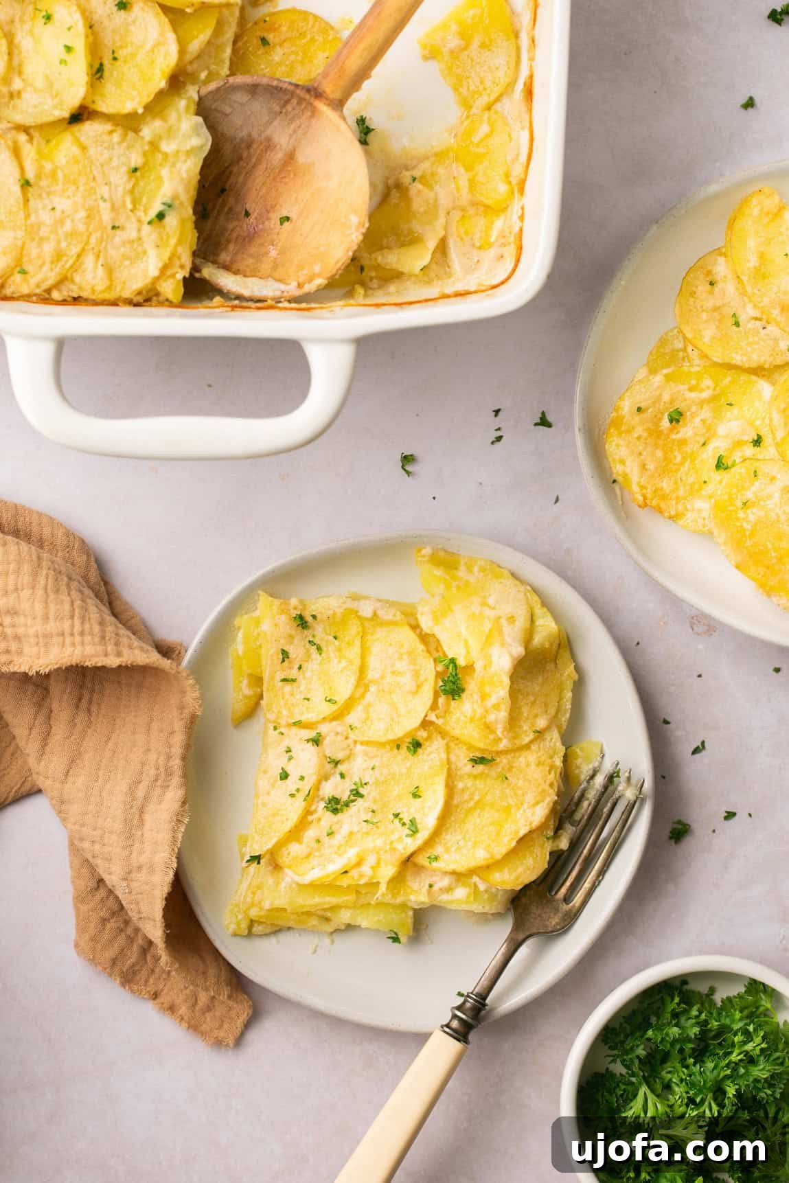 Simple Savory Gluten-Free Potato Gratin 7 a serving of scalloped potatoes on a plate with a fork resting on the side