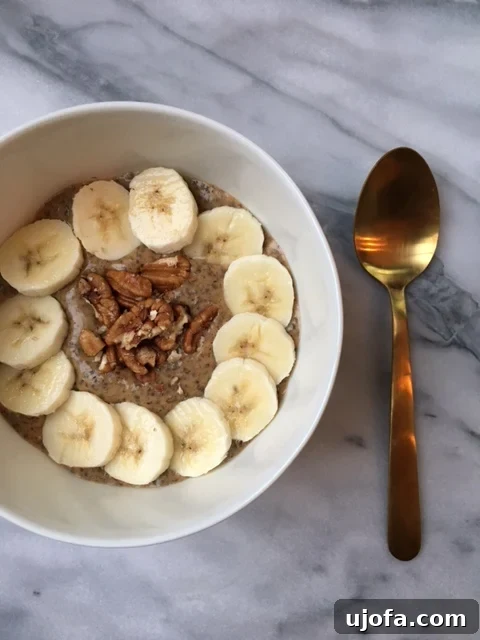 A beautifully presented bowl of Warm Pumpkin Spice Chia Pudding, garnished with fresh berries and nuts, ready to be enjoyed.
