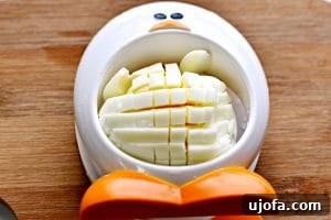 Image demonstrating how to easily chop a hard-boiled egg with a slicer.