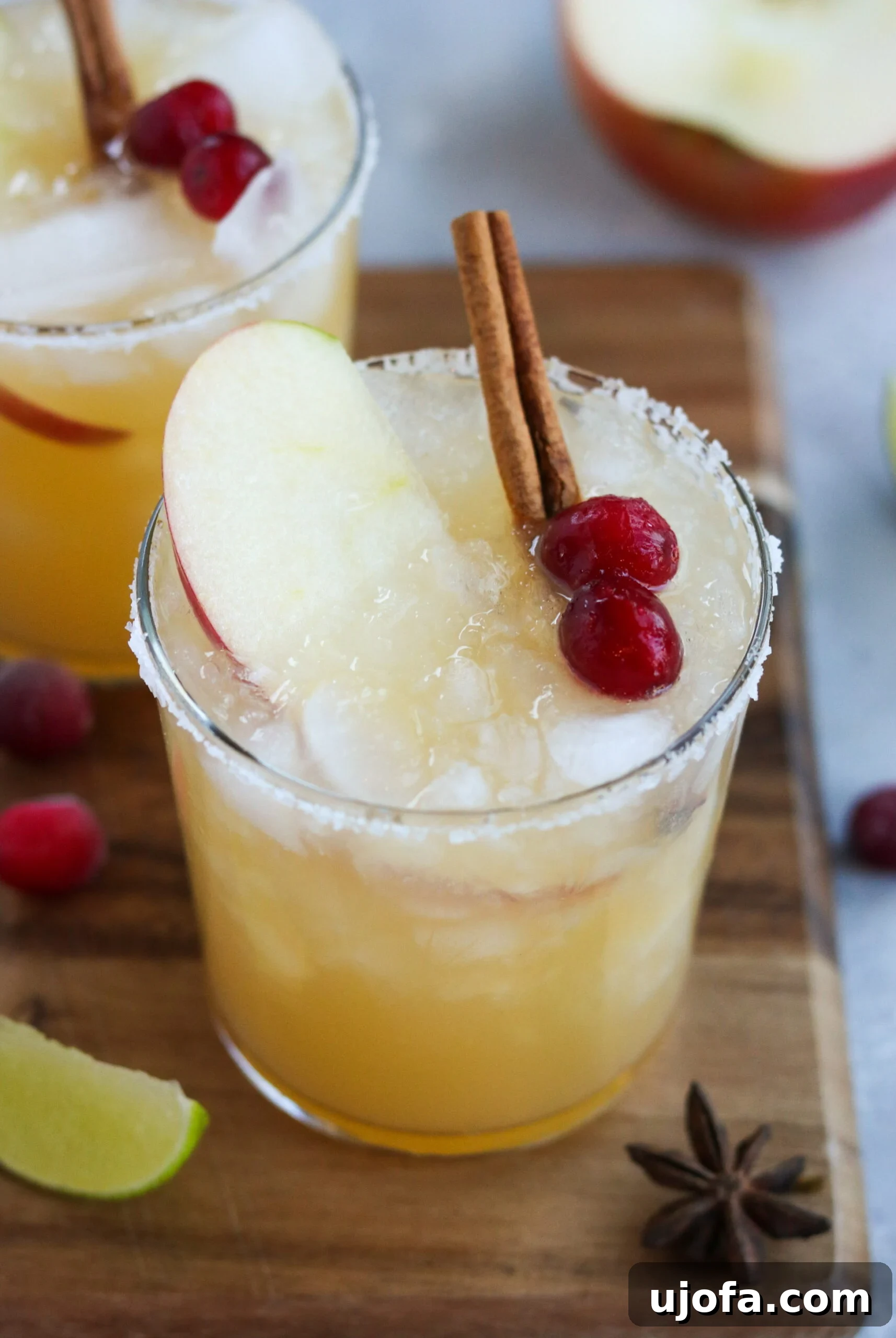 A close-up shot of a Thanksgiving cocktail, showcasing the rich blend of tequila, apple cider, and the delicate swirls of honey cinnamon simple syrup, garnished to perfection.