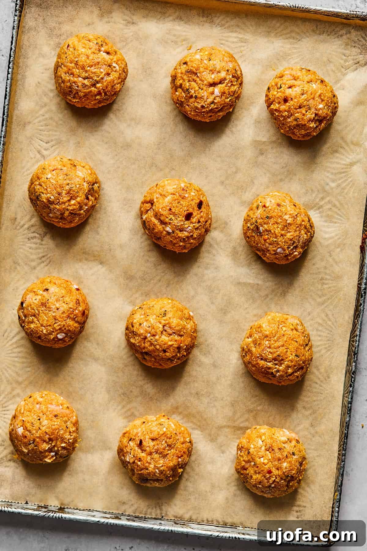 uncooked meatballs on a baking sheet 