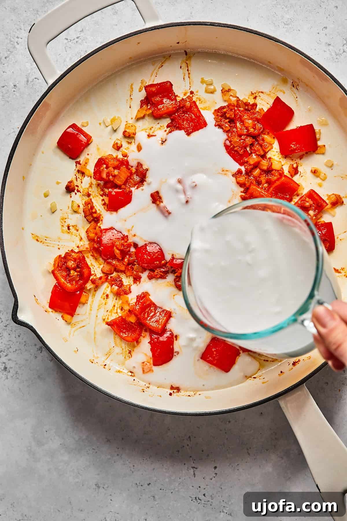 pouring coconut milk into a skillet 