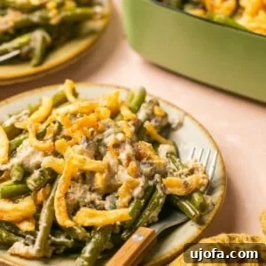 Gluten-free green bean casserole on a plate, generously topped with crispy fried onions