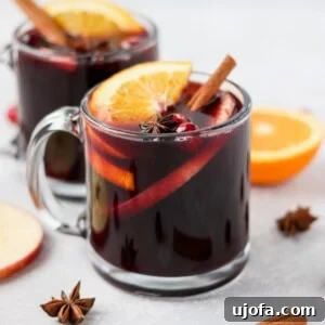 Warm Mulled Wine in festive mugs garnished with orange slices and cinnamon sticks