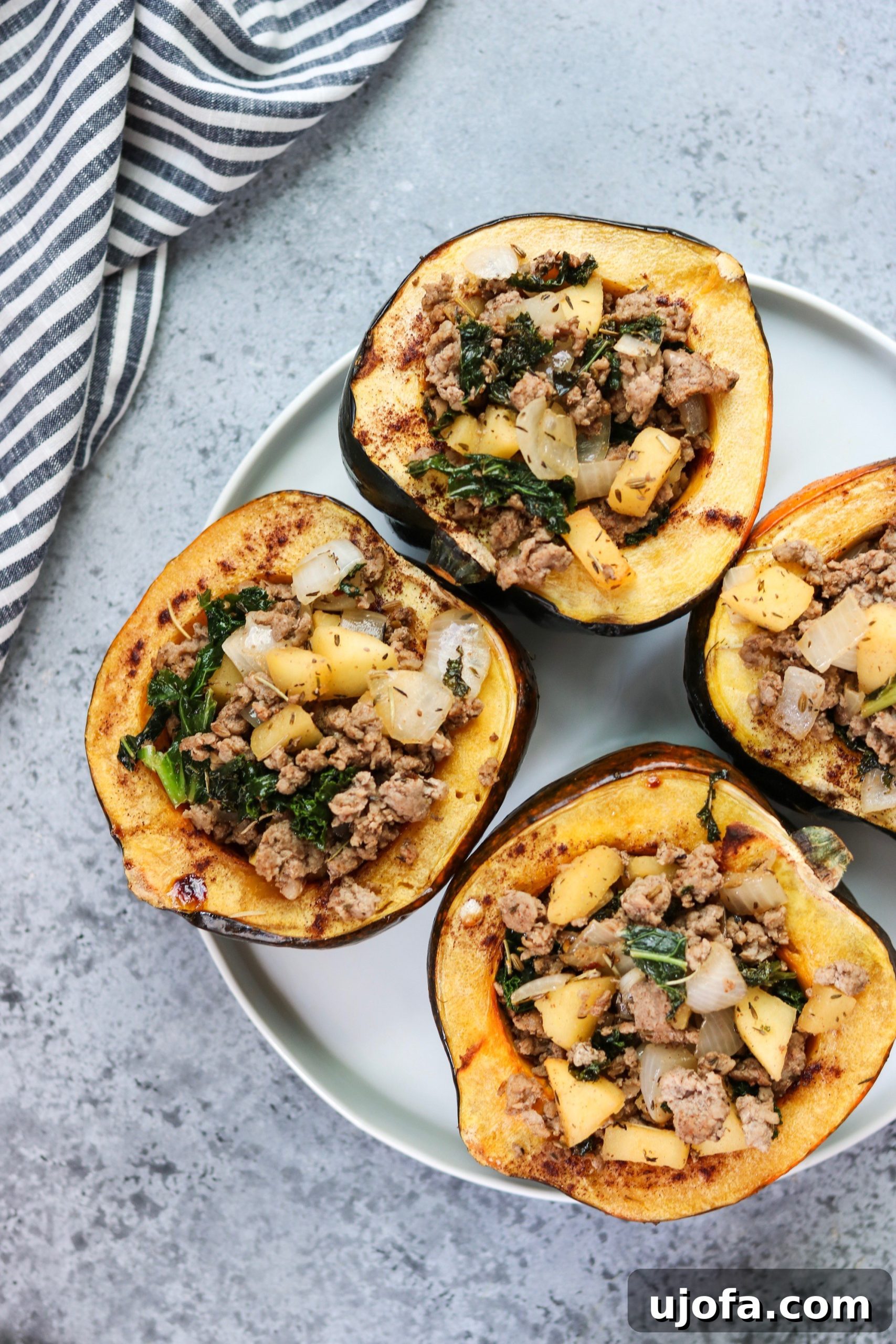 Golden Acorn Harvest Bowls 5 A cutting board with a sliced Honeycrisp apple and fresh kale, highlighting the fresh ingredients used in the stuffing.