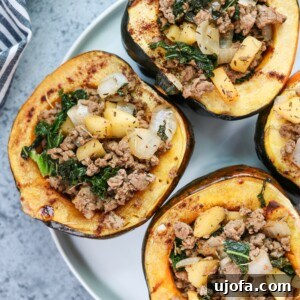 Harvest Stuffed Acorn Squash with savory pork, apple, and kale filling, garnished with herbs.