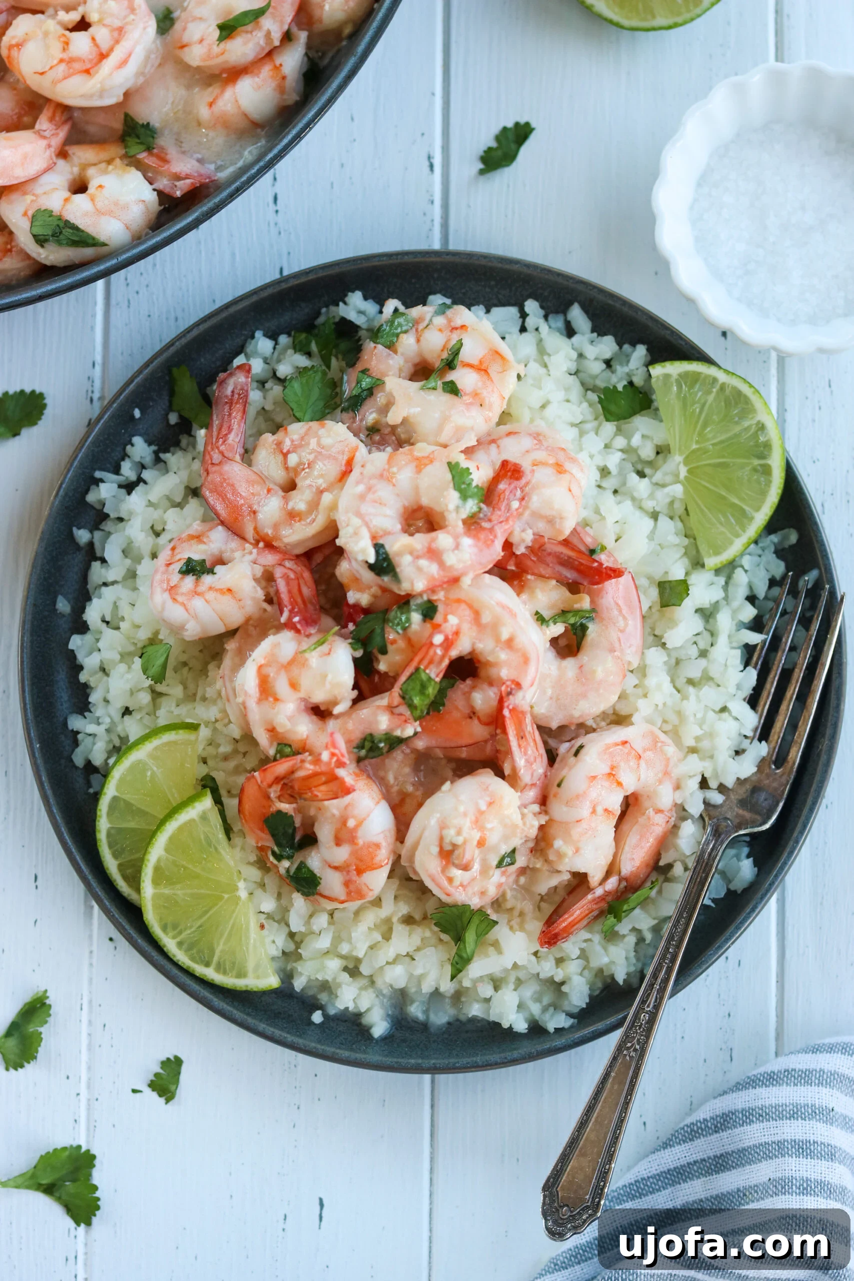 Close-up of cooked coconut lime shrimp in a skillet with a vibrant sauce