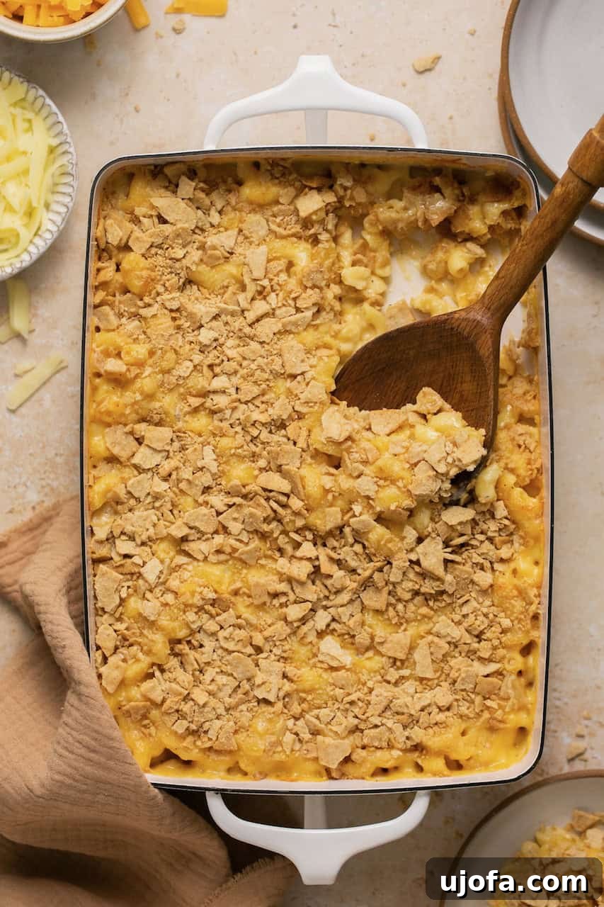 Effortless Gluten-Free Baked Mac and Cheese 7 Baked gluten free mac and cheese with a serving spoon taking out a scoop from the casserole dish.