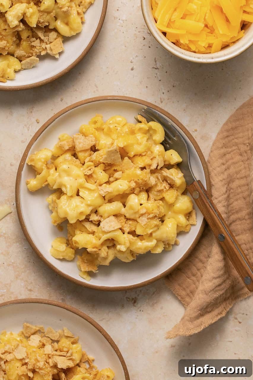 Effortless Gluten-Free Baked Mac and Cheese 8 Two plates of baked gluten free mac and cheese, one with a brown napkin on the side.