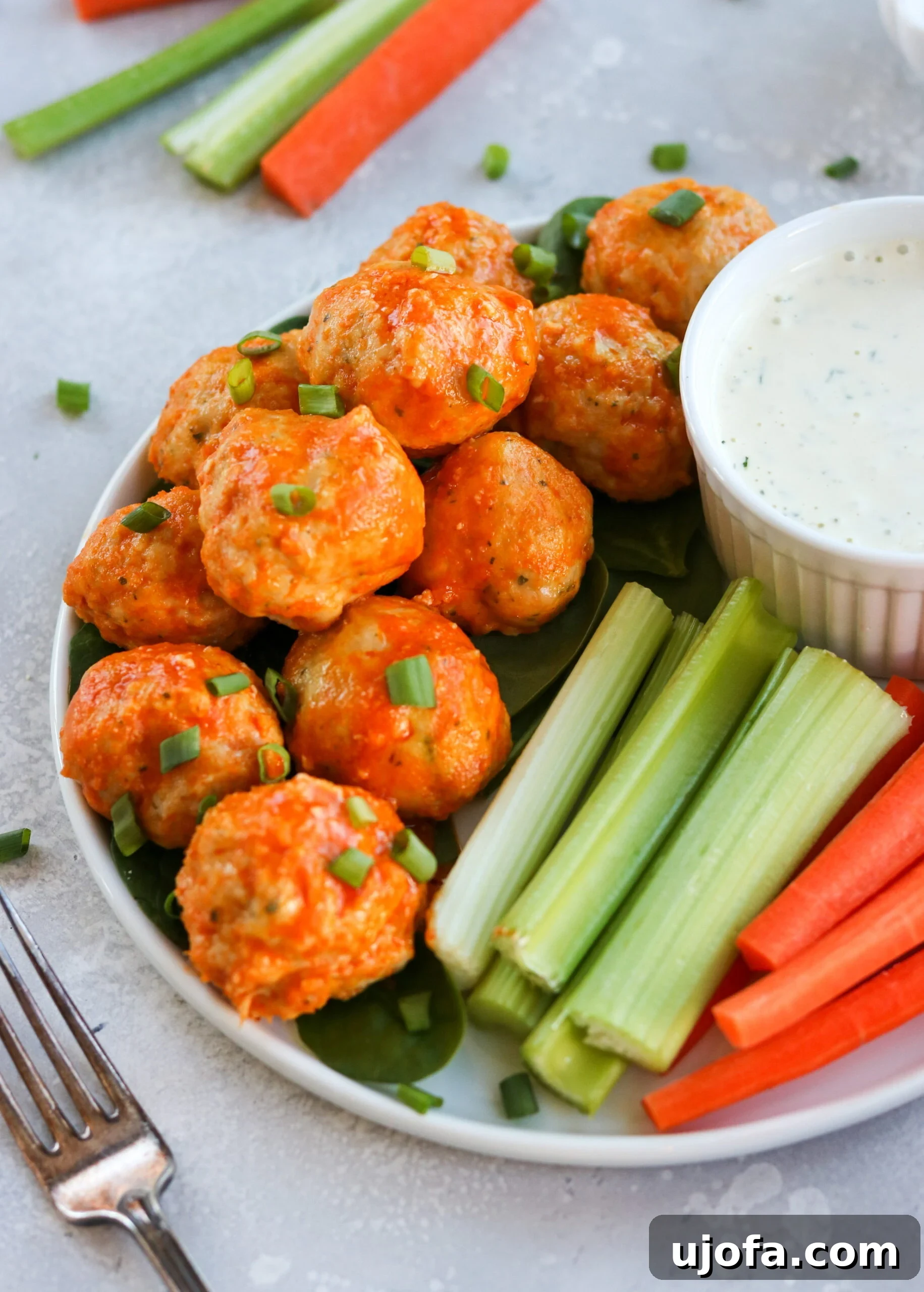 Close-up of golden-brown, gluten-free and dairy-free buffalo chicken meatballs, glistening with sauce and ready to be enjoyed.