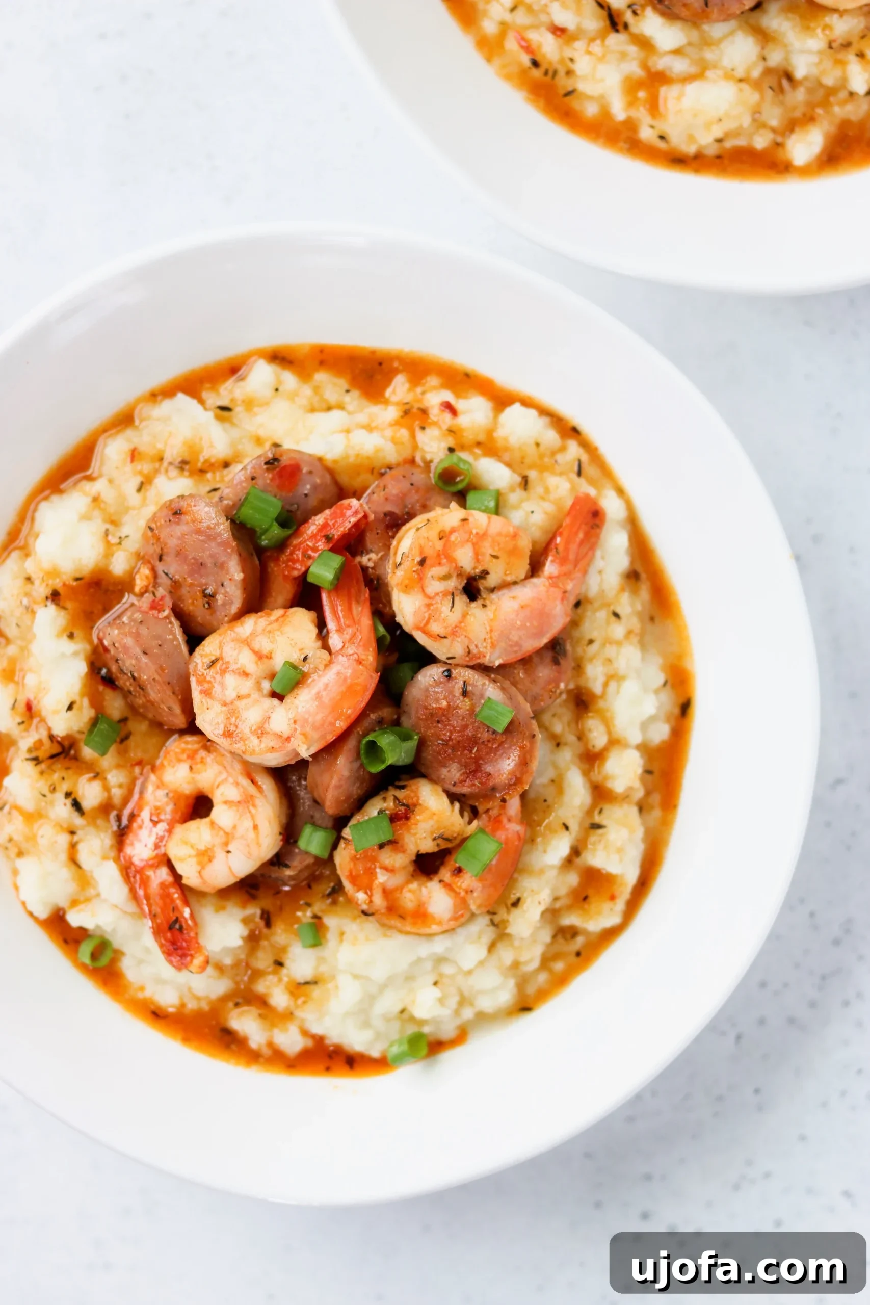 Keto shrimp and cauliflower grits with sausage in a white bowl
