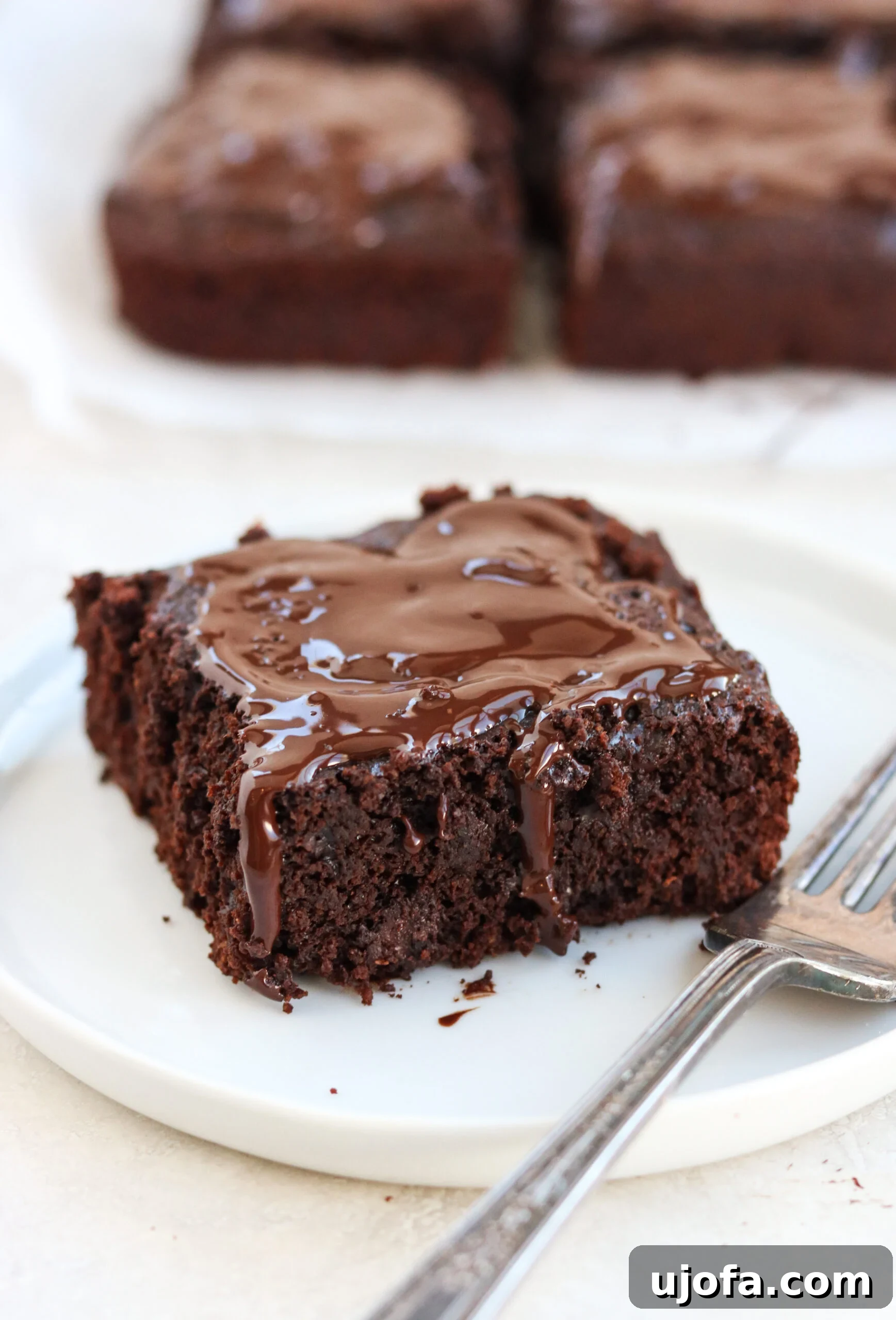 a close-up shot of a single Paleo Double Chocolate Thin Mint Brownie, highlighting its moist interior and chocolate drizzle