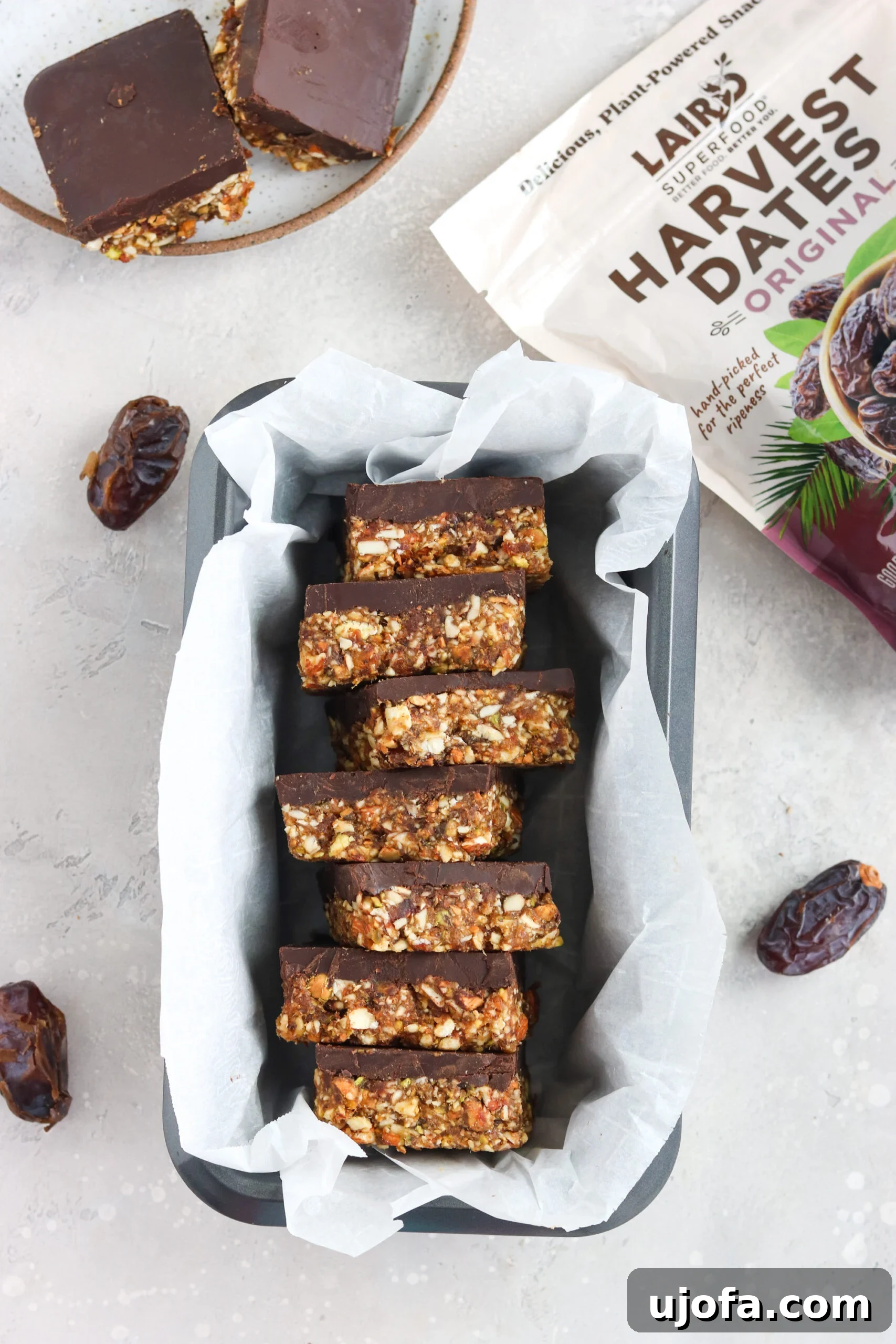 Fudge Covered Date Nut Bars in a Pan Freshly made fudge-covered date and nut bars neatly arranged in a square baking pan, ready to be chilled and sliced.