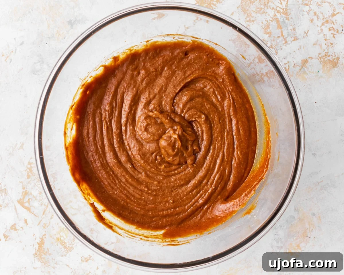 Wholesome Gluten-Free Pumpkin Delights 10 Gluten-free pumpkin muffin batter in a glass bowl after combining wet and dry ingredients.