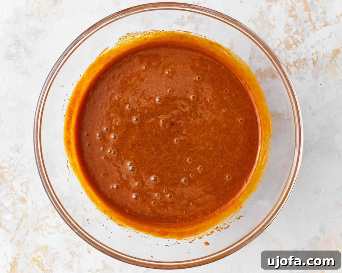 Wholesome Gluten-Free Pumpkin Delights 9 Wet ingredients for gluten-free pumpkin muffins, including pumpkin puree, combined in a glass mixing bowl.