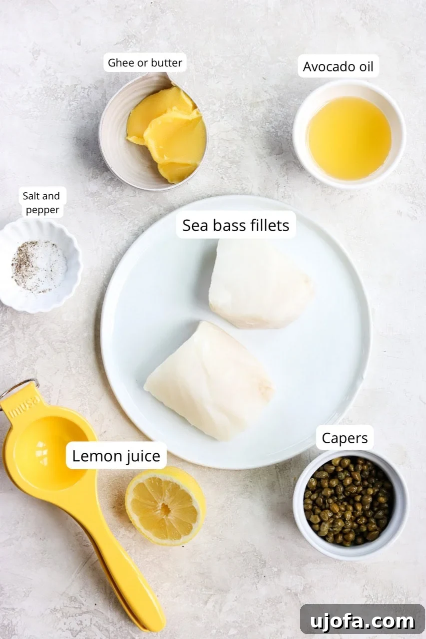20-Minute Chilean Sea Bass with Bright Lemon Caper Butter 3 A collection of fresh ingredients for the Chilean sea bass recipe, including vibrant Chilean sea bass fillets, bright lemons, aromatic capers, creamy butter, and essential seasonings, all arranged on a white plate.