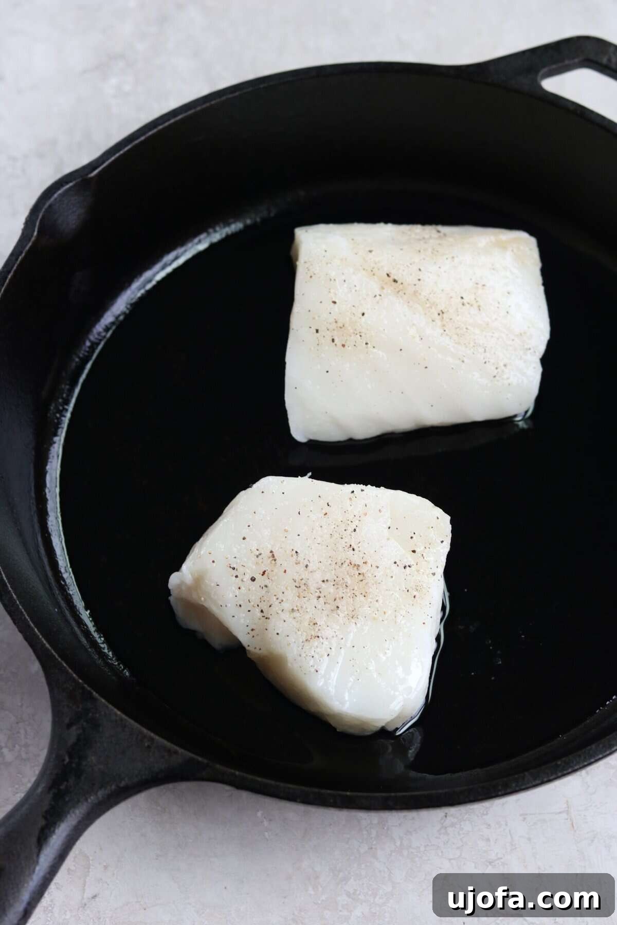 20-Minute Chilean Sea Bass with Bright Lemon Caper Butter 6 Two glistening sea bass fillets sizzling in a hot cast-iron pan, skin-side down, forming a perfect crust.