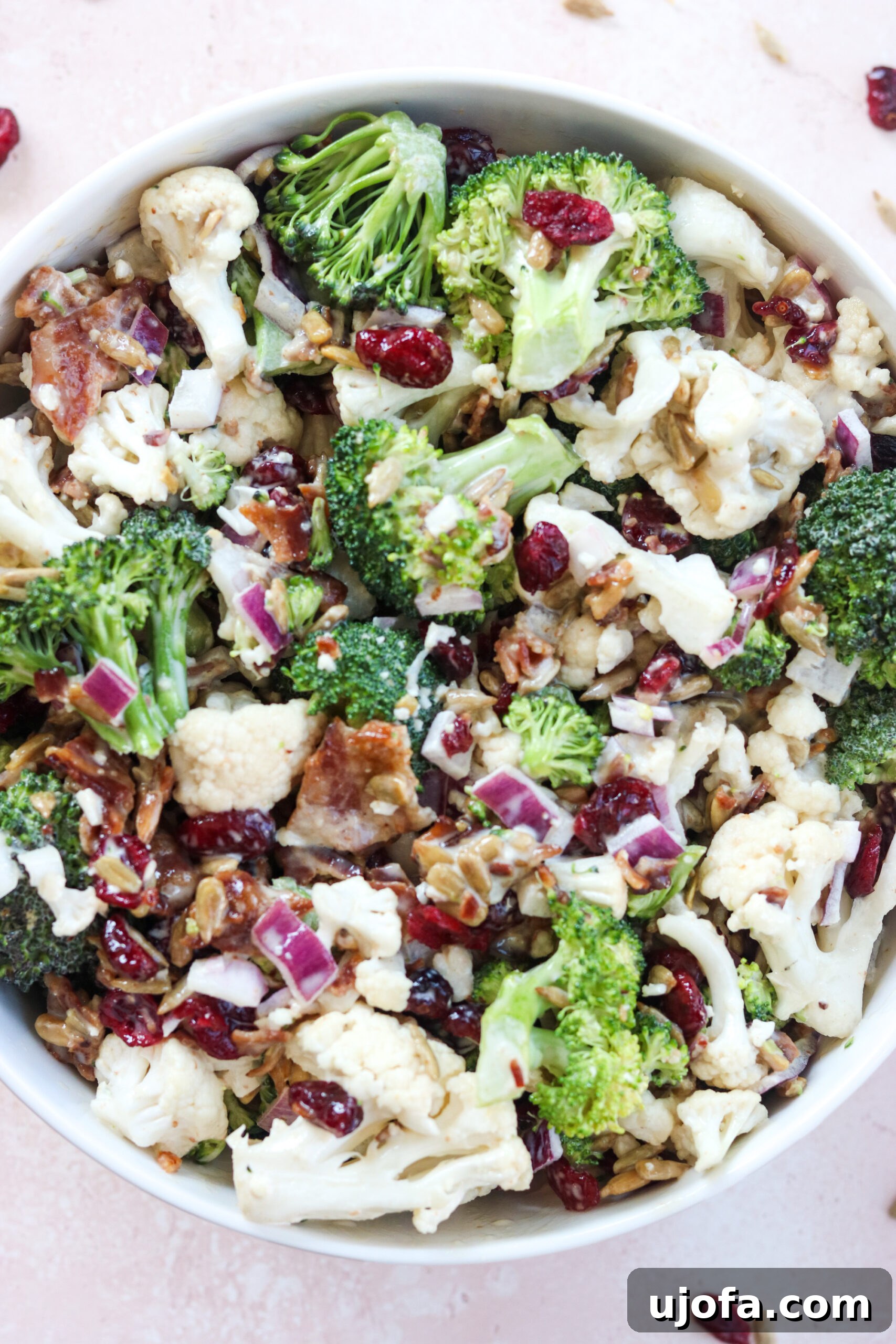 salad with broccoli and cailiflower Paleo Broccoli Cauliflower Salad on a white bowl