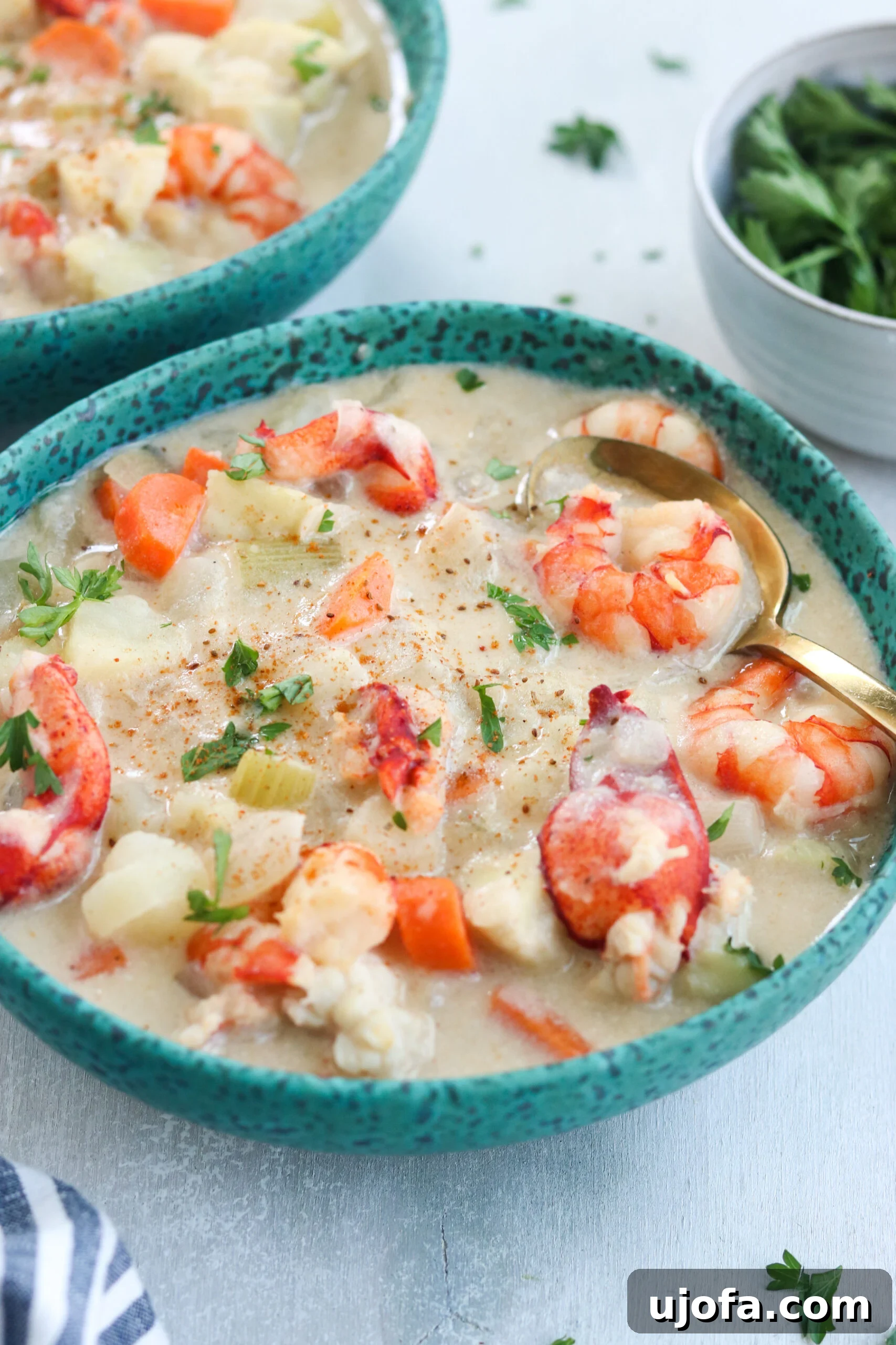 Delicious Paleo Seafood Chowder A close-up shot of a steaming bowl of Paleo Seafood Chowder, showing chunks of fish, shrimp, and vegetables.