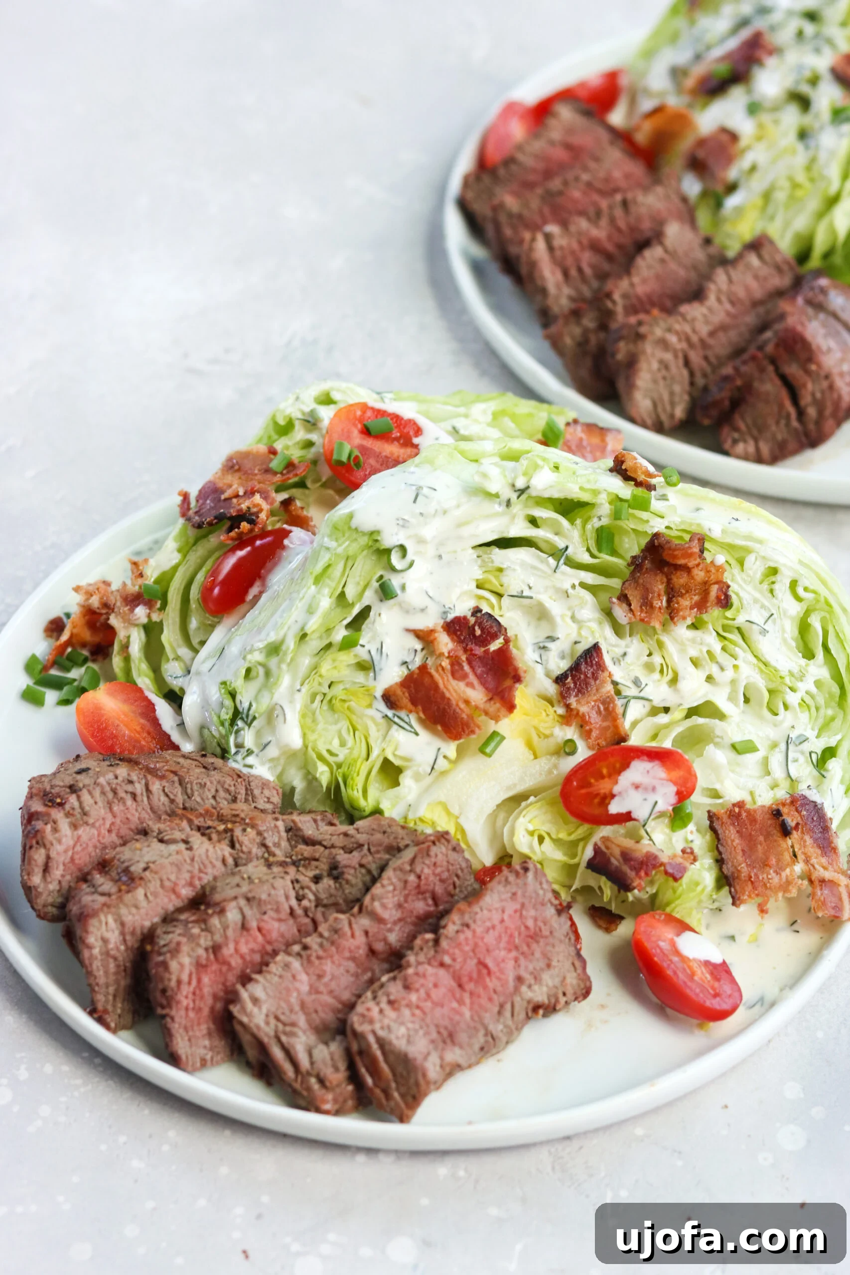 Delicious Steakhouse Wedge Salad with Homemade Dairy-Free Ranch (Paleo/Whole30) Two plates of Steakhouse Wedge Salad with Homemade Ranch, highlighting a perfectly grilled filet, crisp lettuce, and vibrant toppings, suitable for Paleo and Whole30 diets.