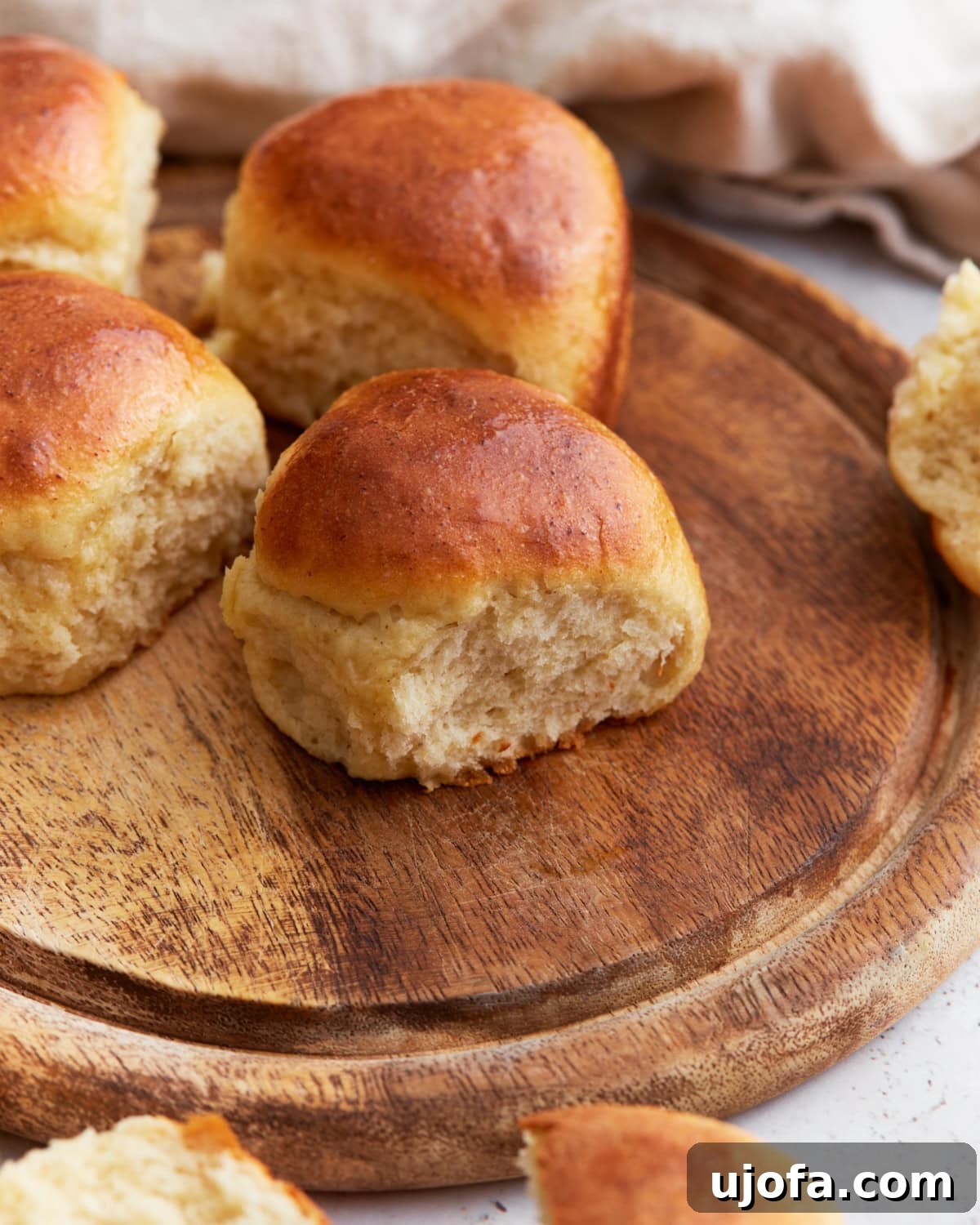 Basket of warm, golden-brown gluten-free dinner rolls brushed with melted butter