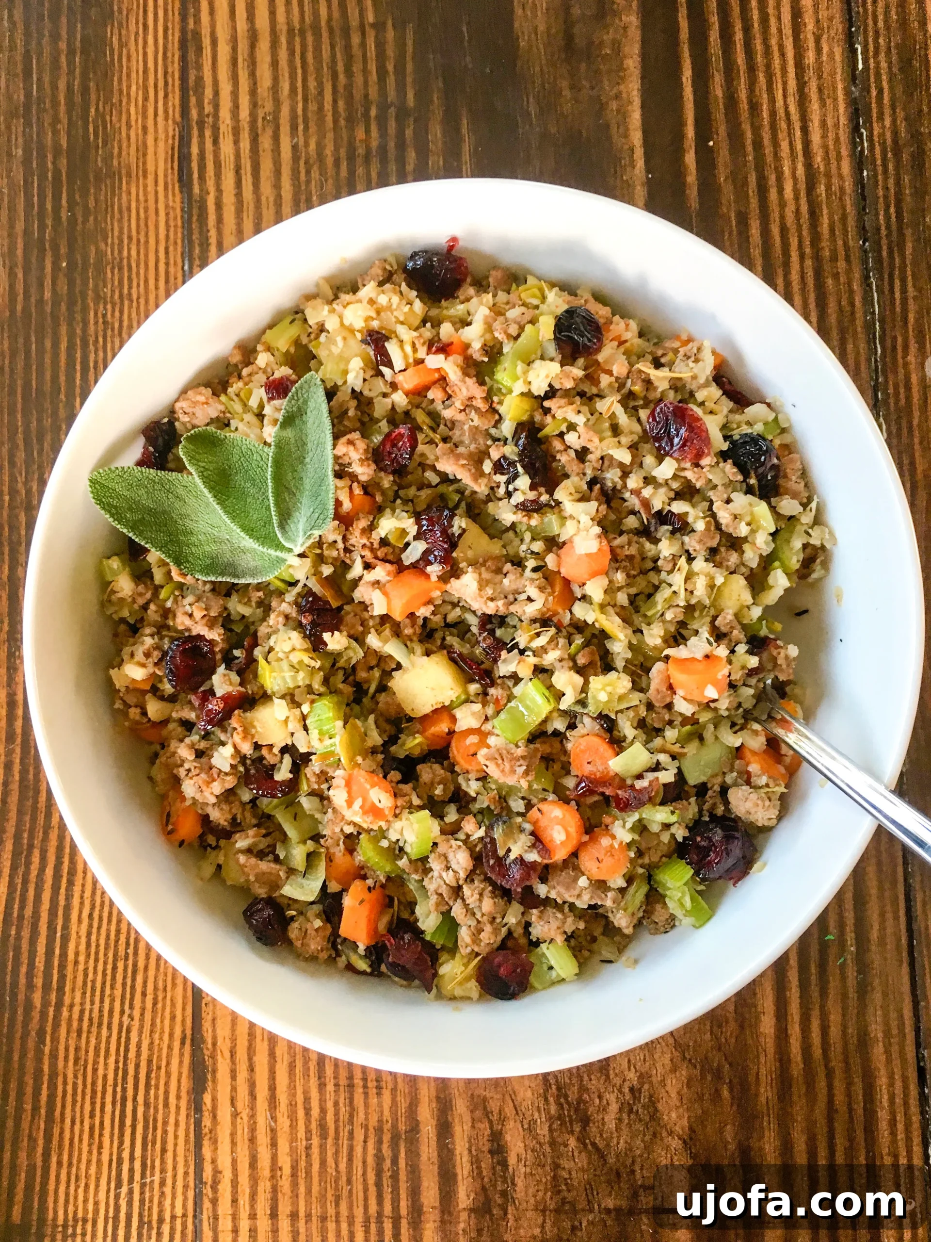 Savory Sausage and Cauliflower Rice Stuffing Whole30 Keto Paleo 3 keto cauliflower stuffing in a white bowl garnished with fresh sage
