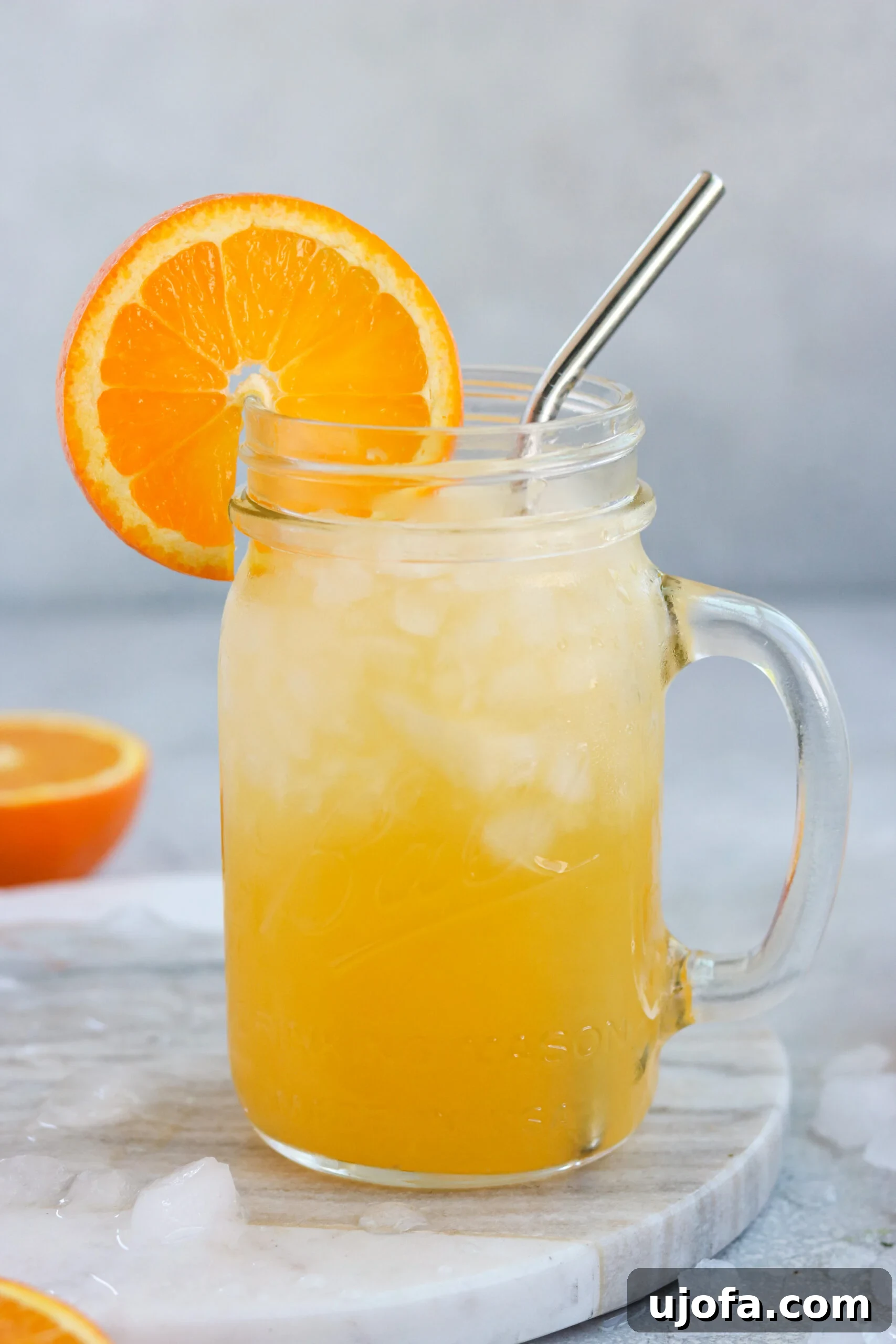 orange cocktail on a mason jar with steel straw