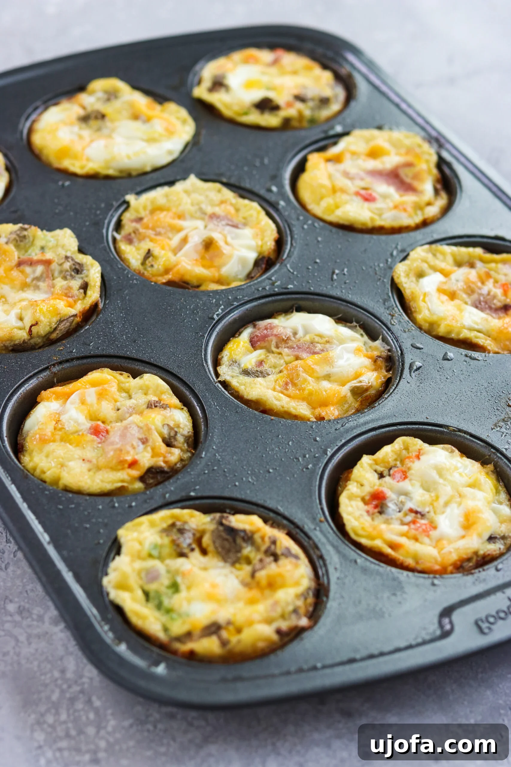 Western Omelette Egg Bites on a baking pan Western Omelette Egg Bites baking in a muffin pan