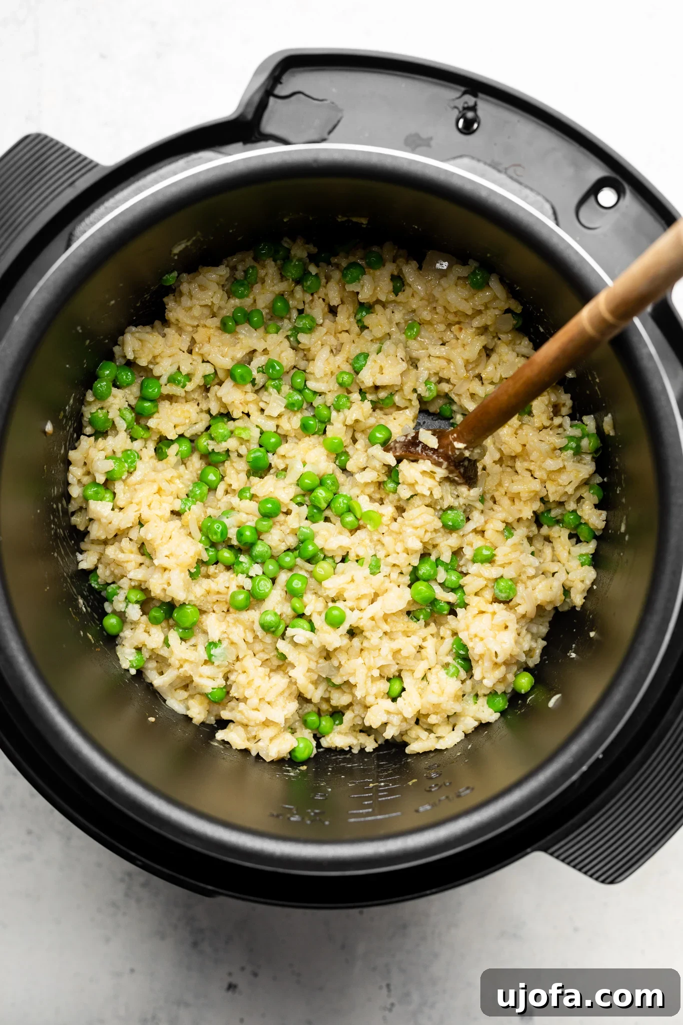 rice and peas in an instant pot with a wooden spoon