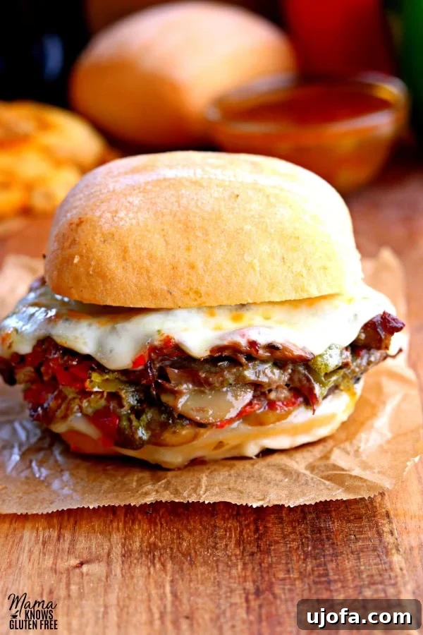 Fork-Tender Instant Pot Steak Sandwiches 2 Instant Pot steak sandwich on brown parchment paper with French fries, a roll and au jus in the background, highlighting its deliciousness.