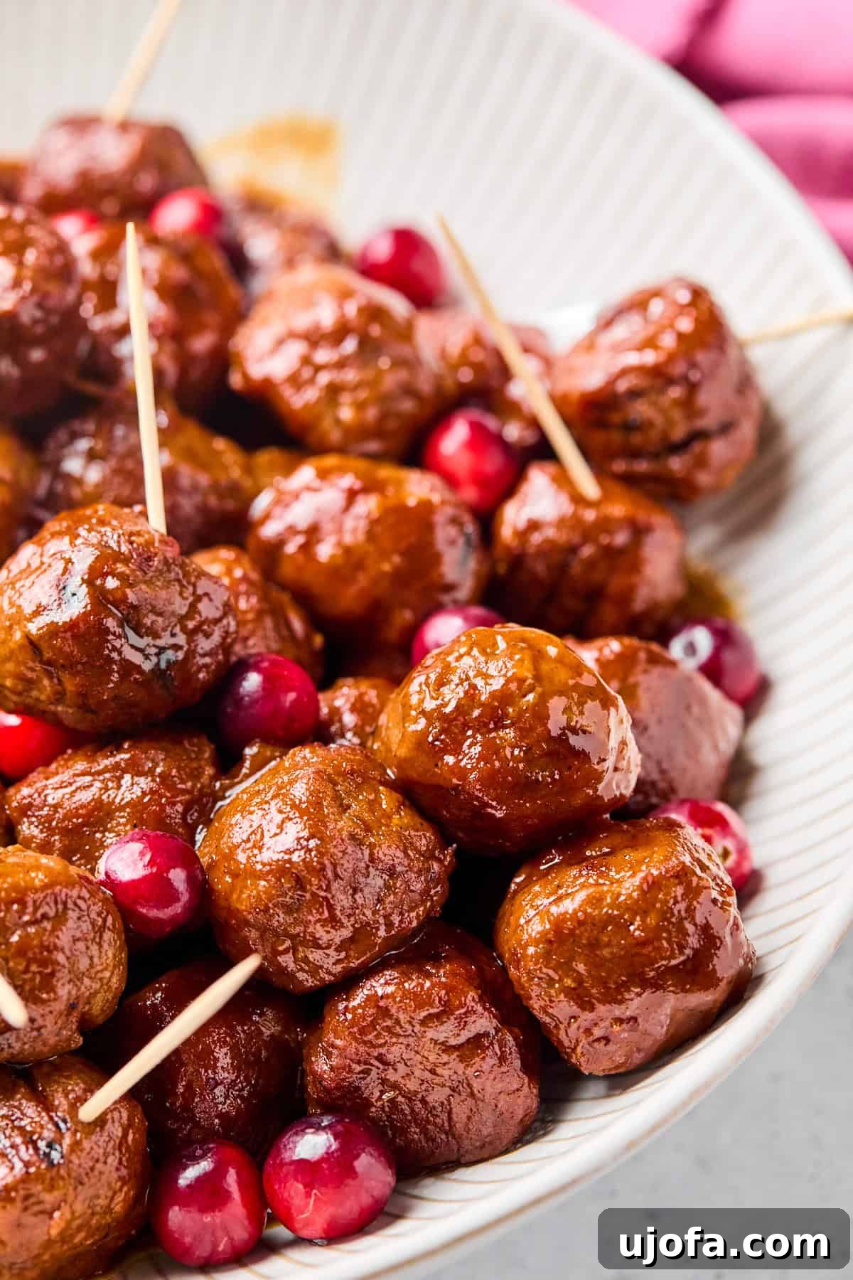 cranberry jalapeno meatballs with toothpicks in a white bowl