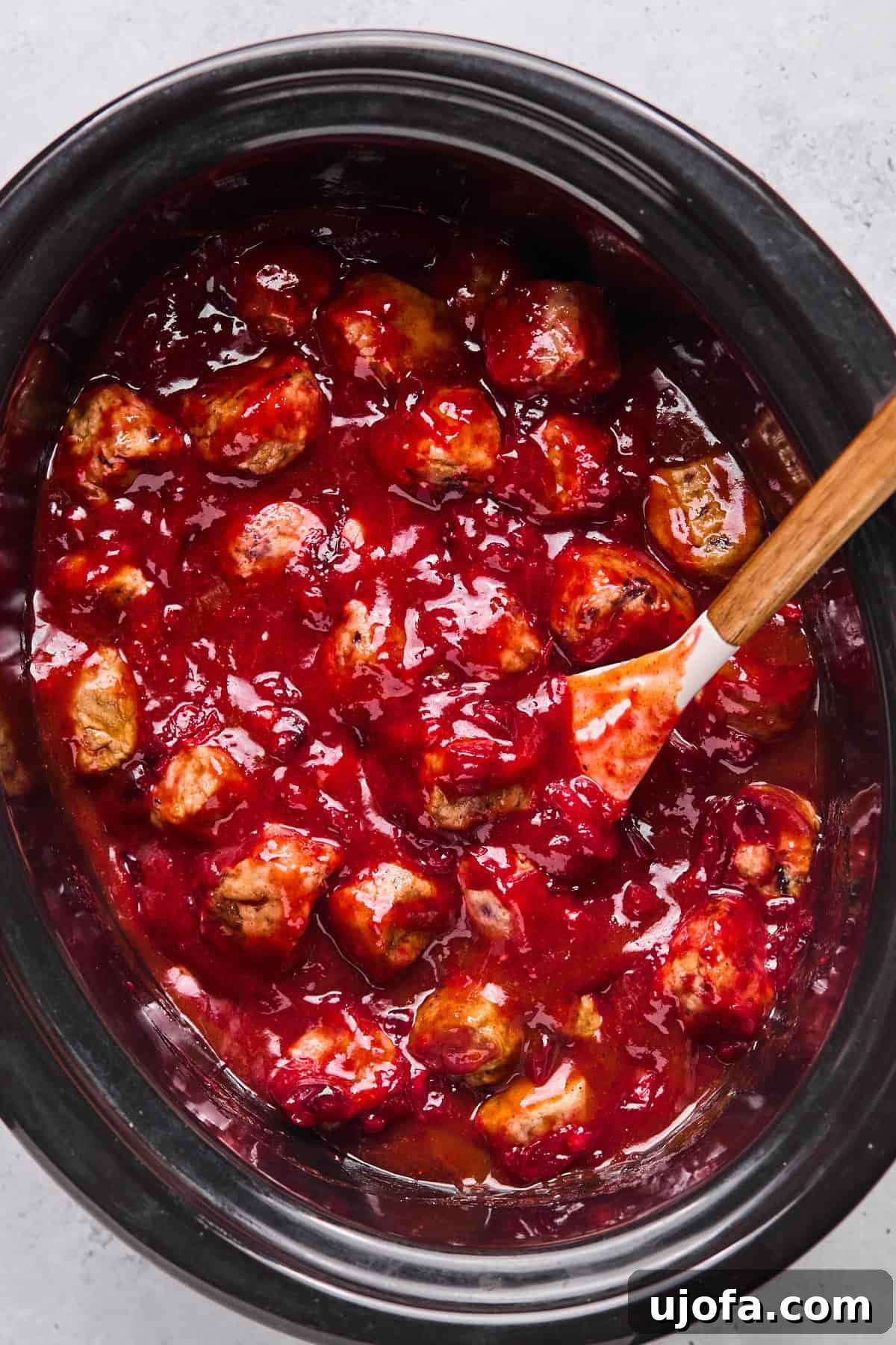 meatballs cooking in sauce in a crock pot 