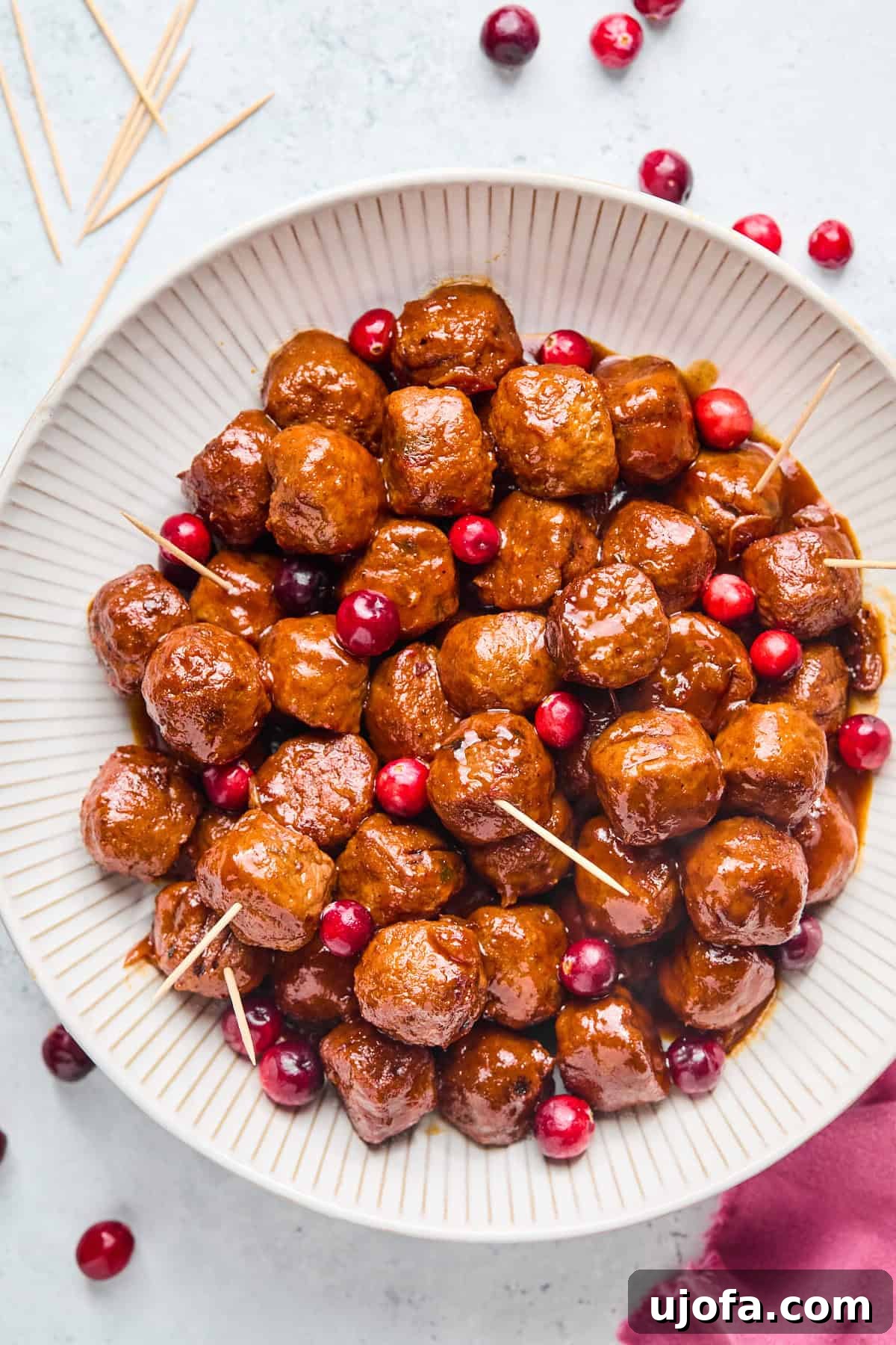 cranberry jalapeno meatballs with toothpicks in a white bowl
