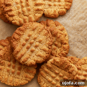 gluten-free peanut butter cookies stacked around each other on parchment paper, ready to be enjoyed