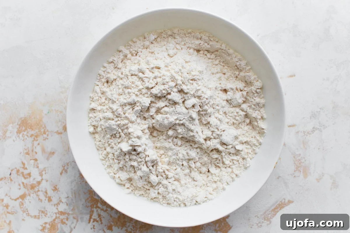 A small white bowl containing a perfectly blended gluten-free flour mixture, ready for the next step.